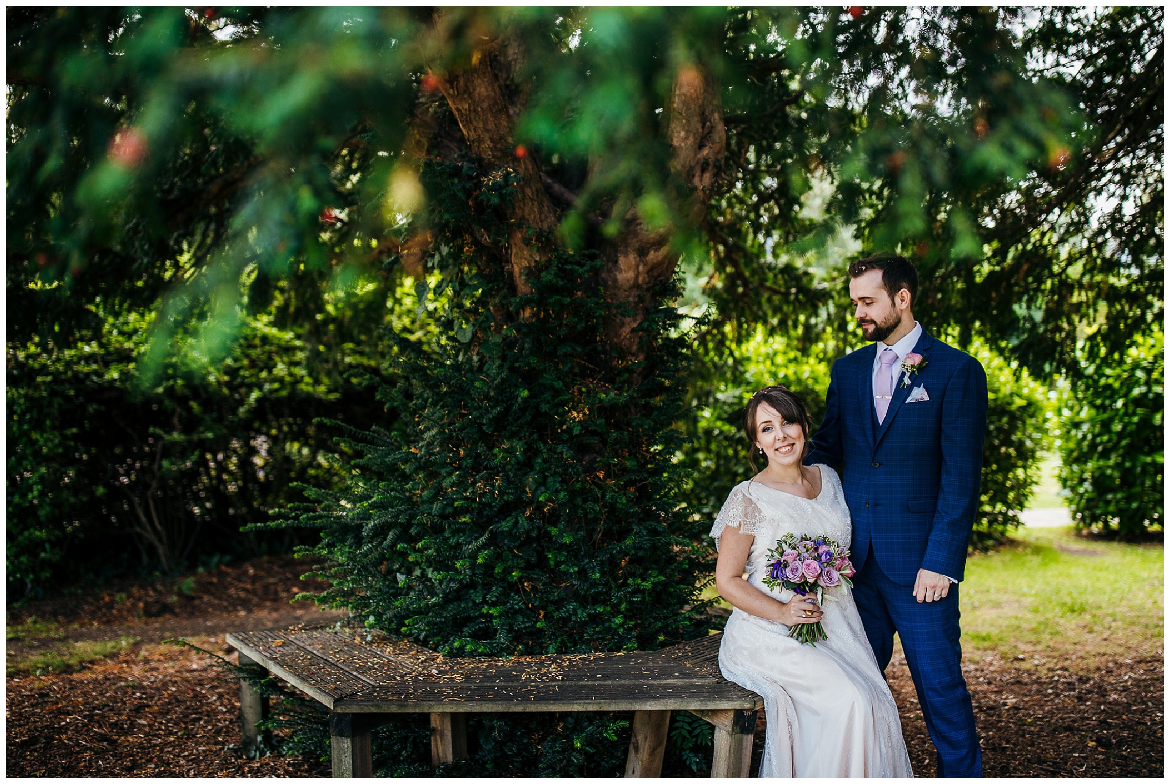 bride and groom sit in shade under tree