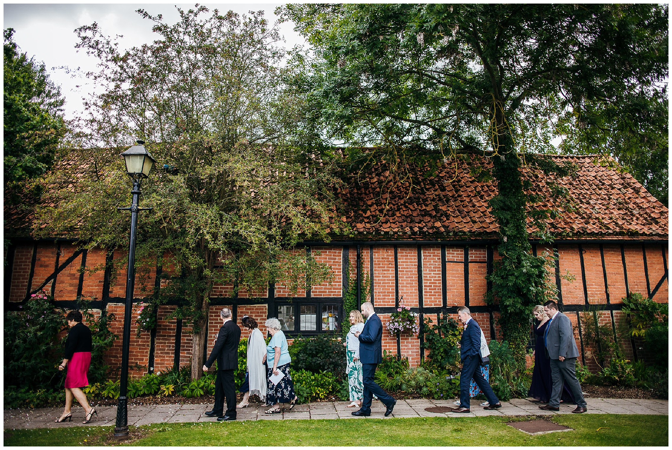 wedding guests walking alongside barn