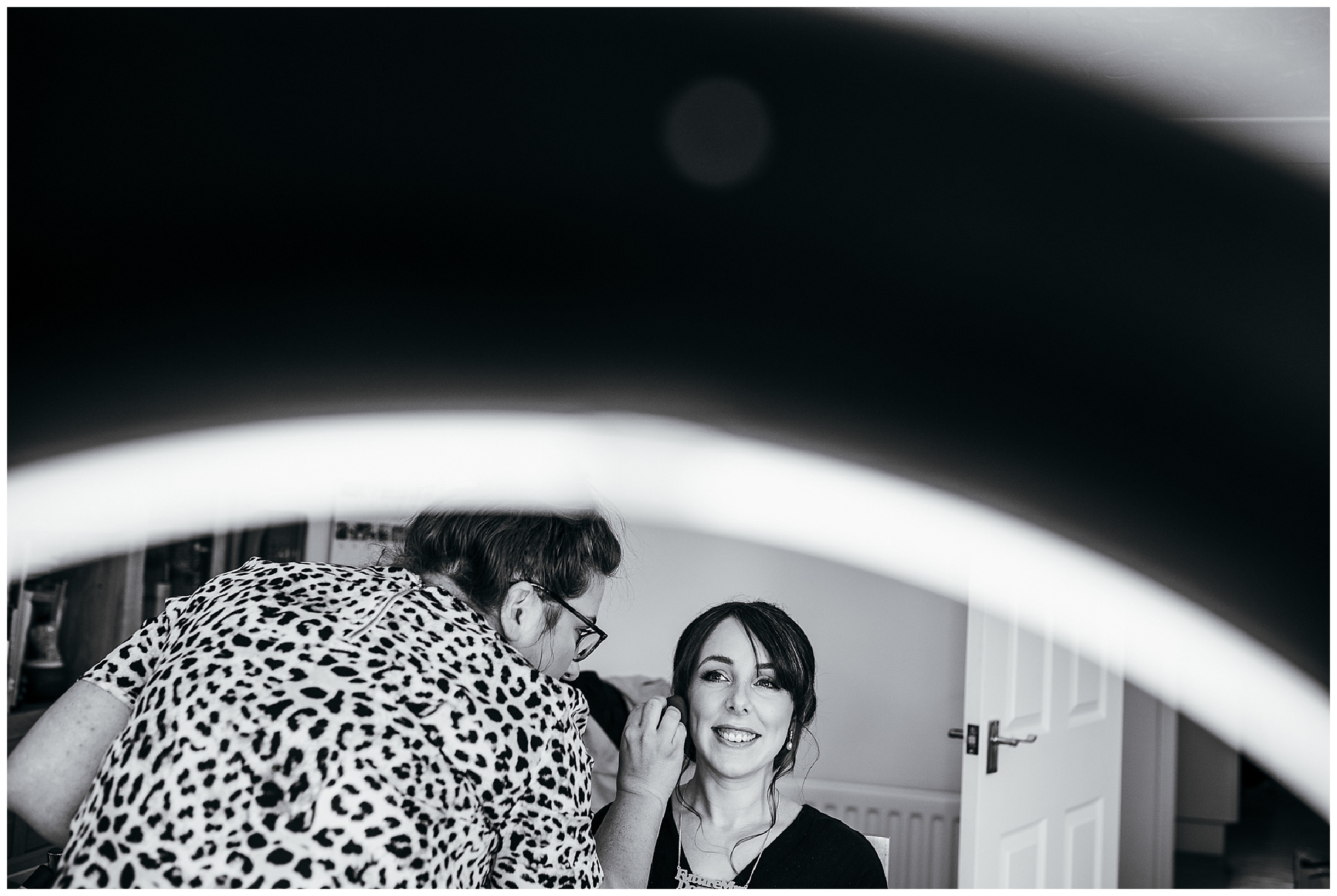 black and white image of bride having make up applied by a make up artist