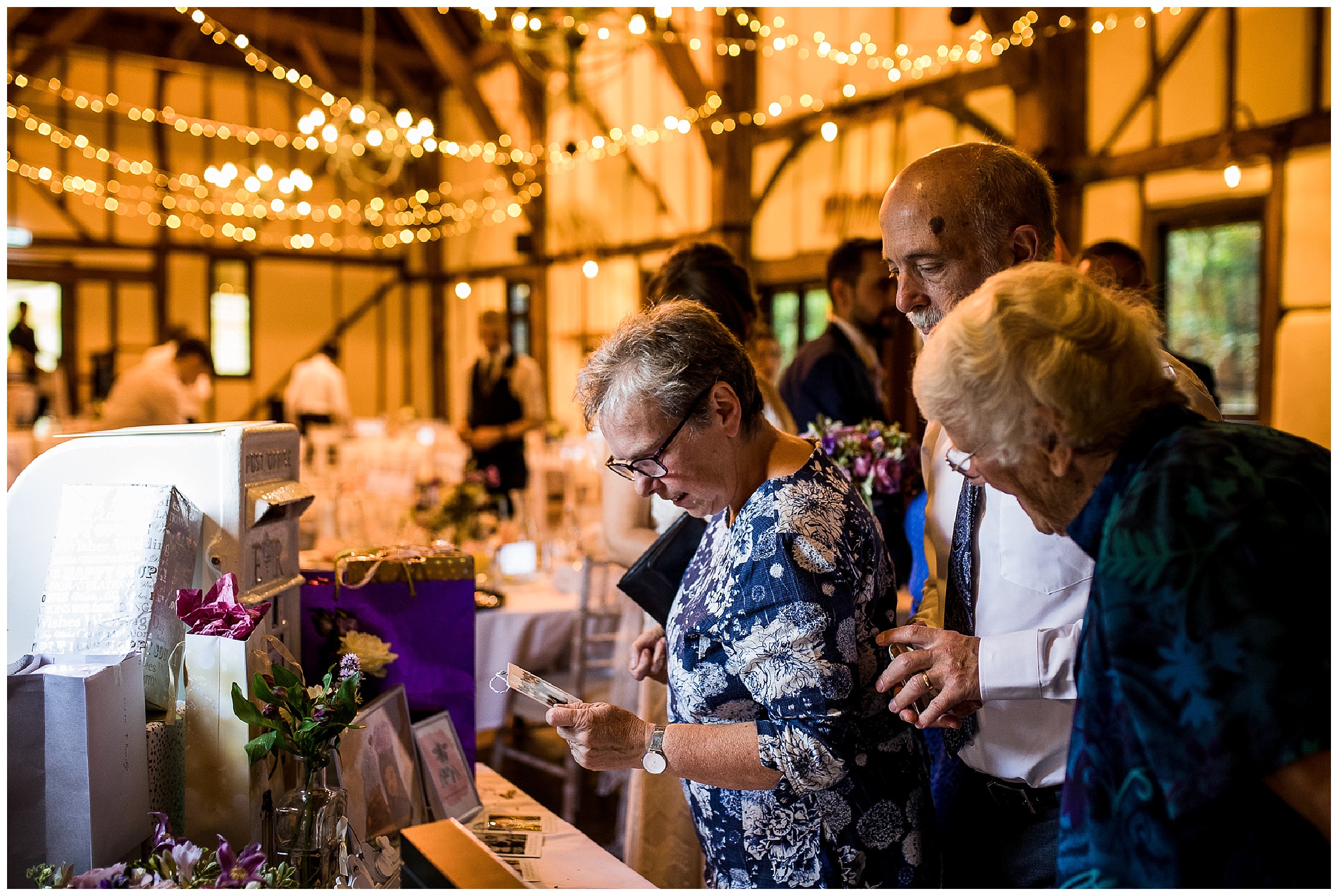 wedding guests in barn looking at card table