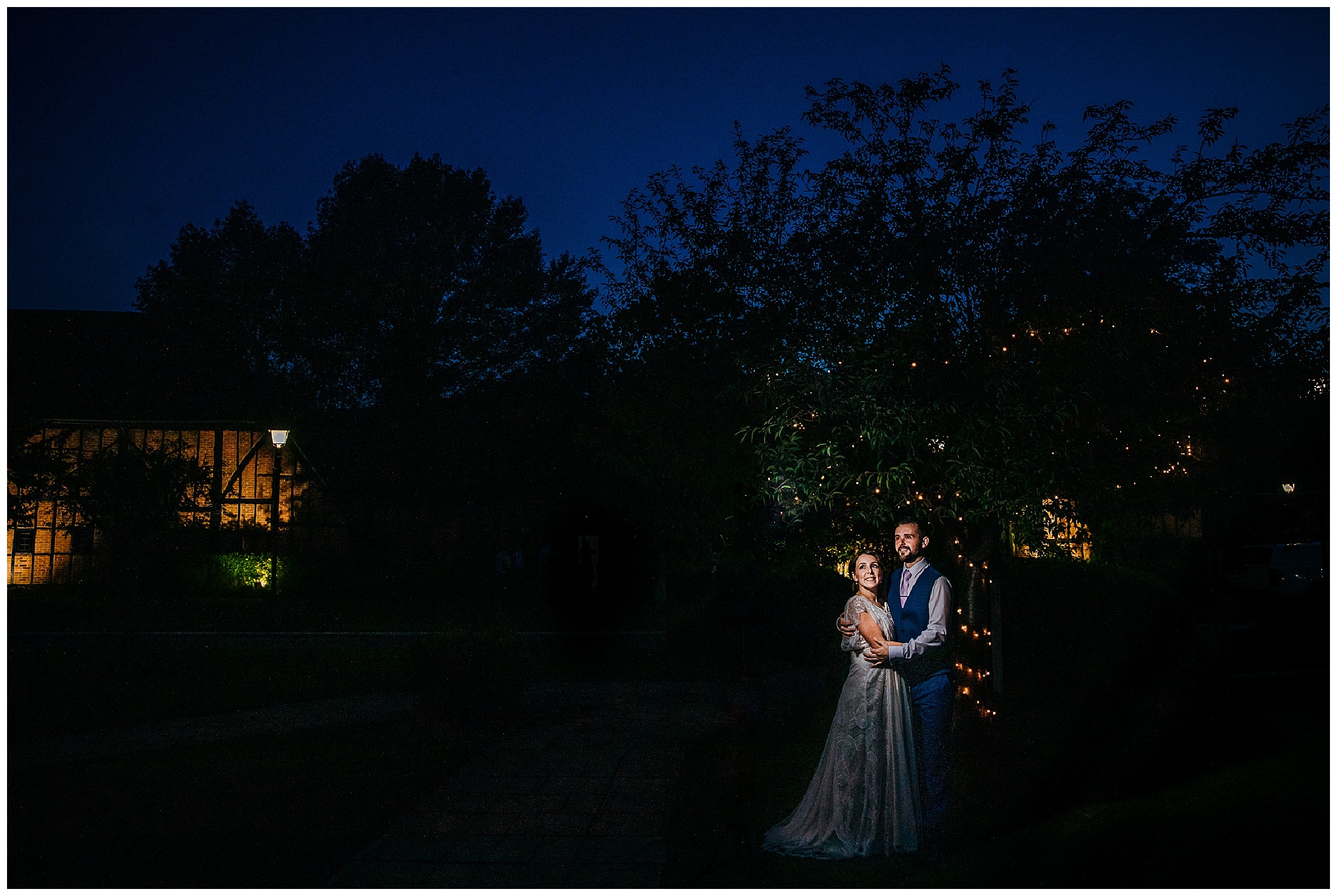 bride and groom in dark illuminated by light at barns hotel bedford