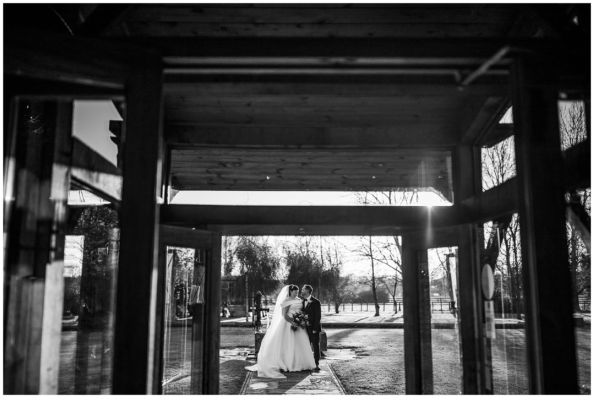 wide shot of bride and groom in front of water feature at tythe barn in launton