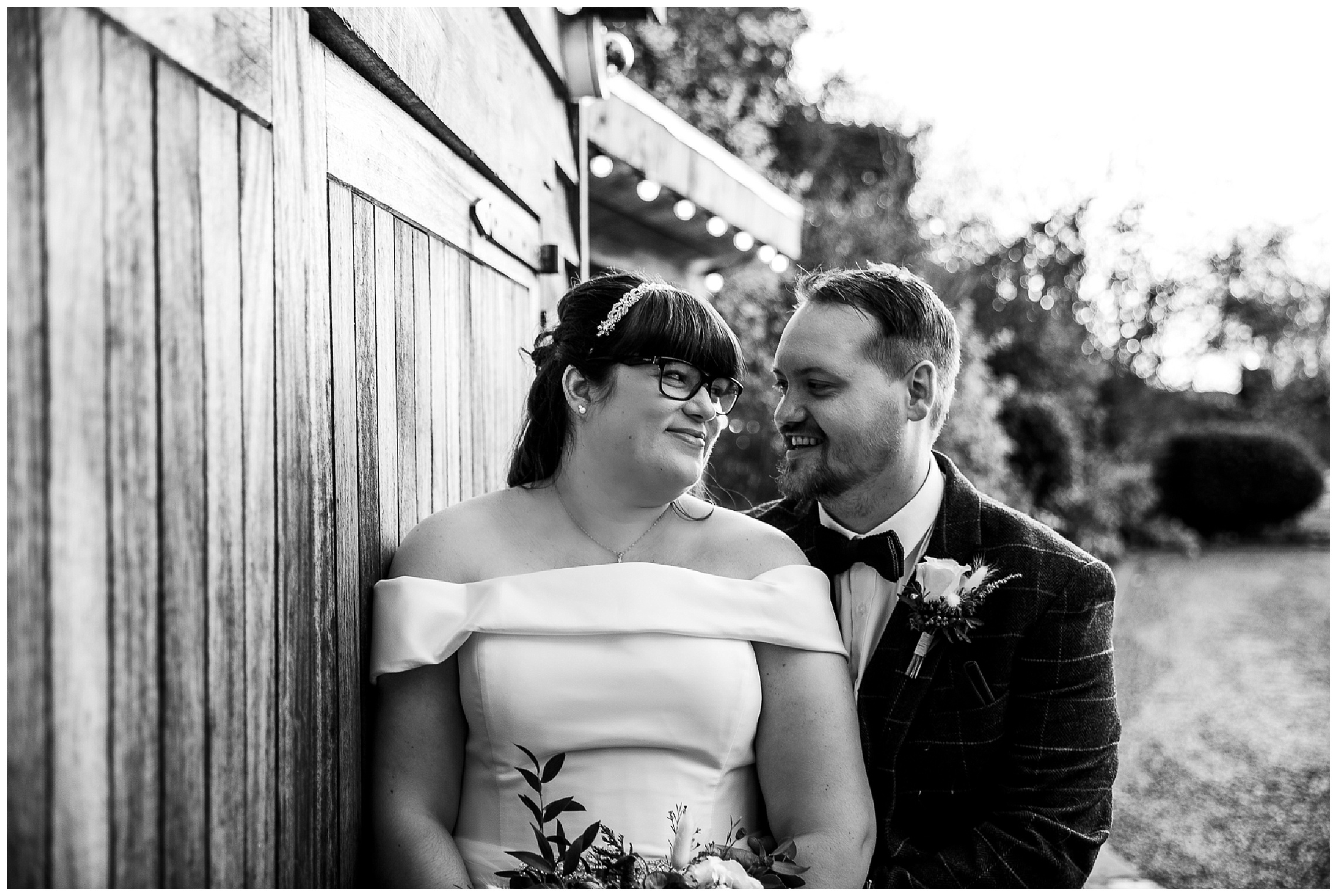 bride and groom smiling together outside barn