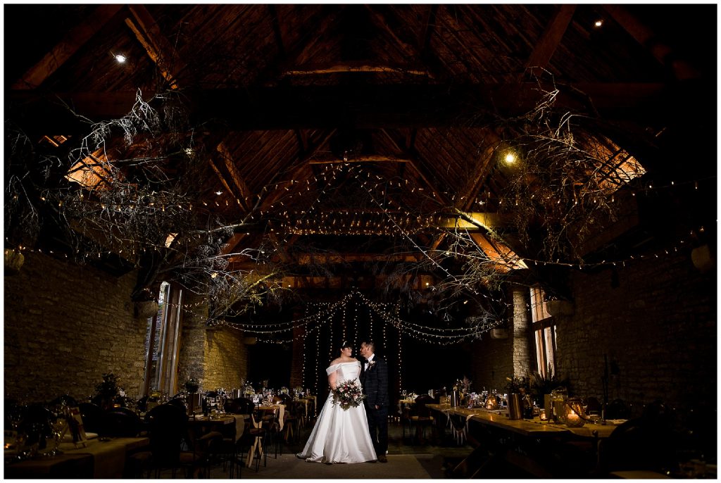 bride and groom lit in the middle of tythe barn in launton