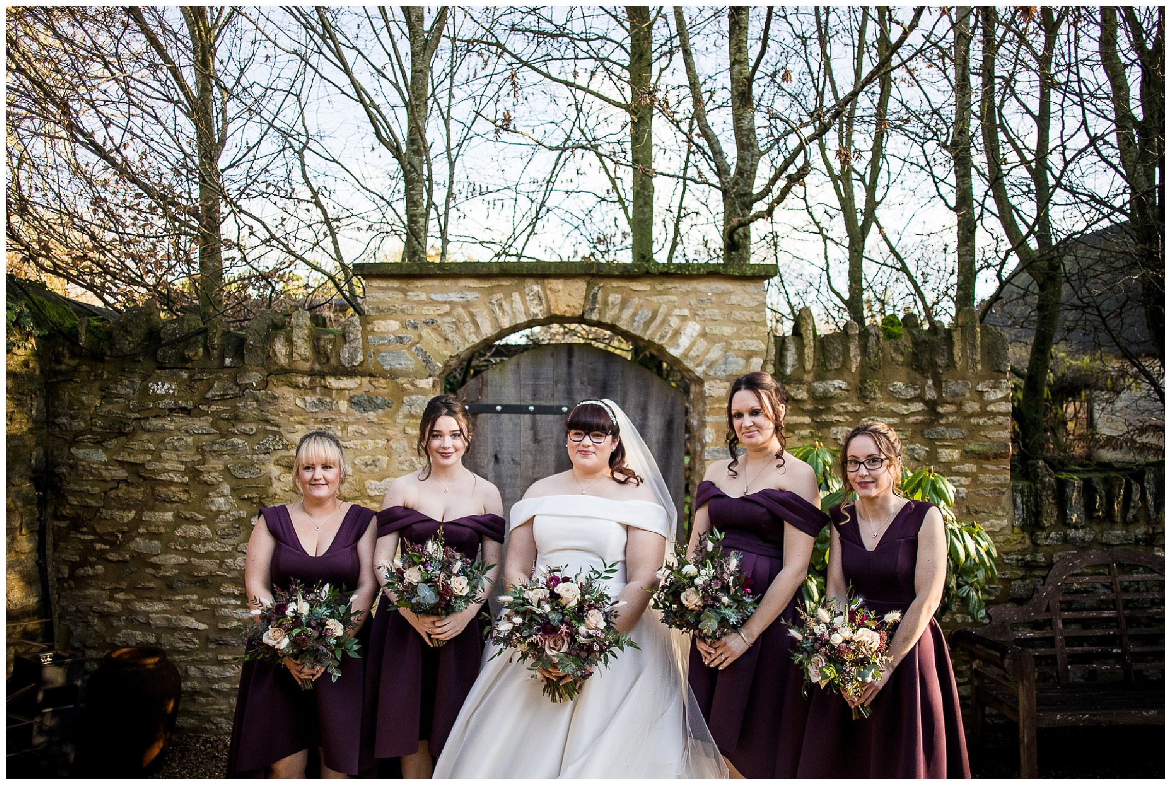 bride with four bridesmaids in deep burgundy dresses