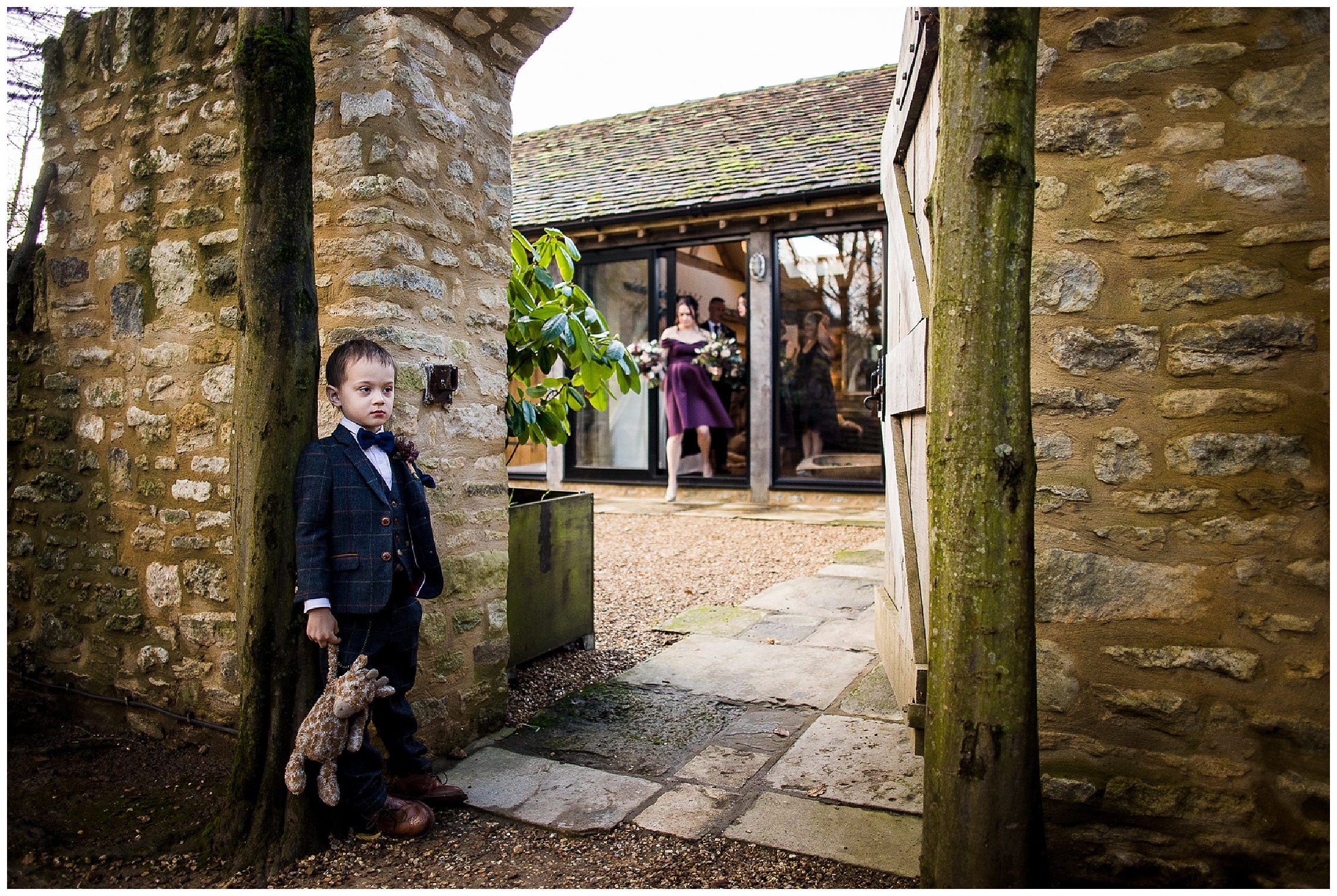 brides son holds onto his giraffe teddy bear as he waits outside bridal nook