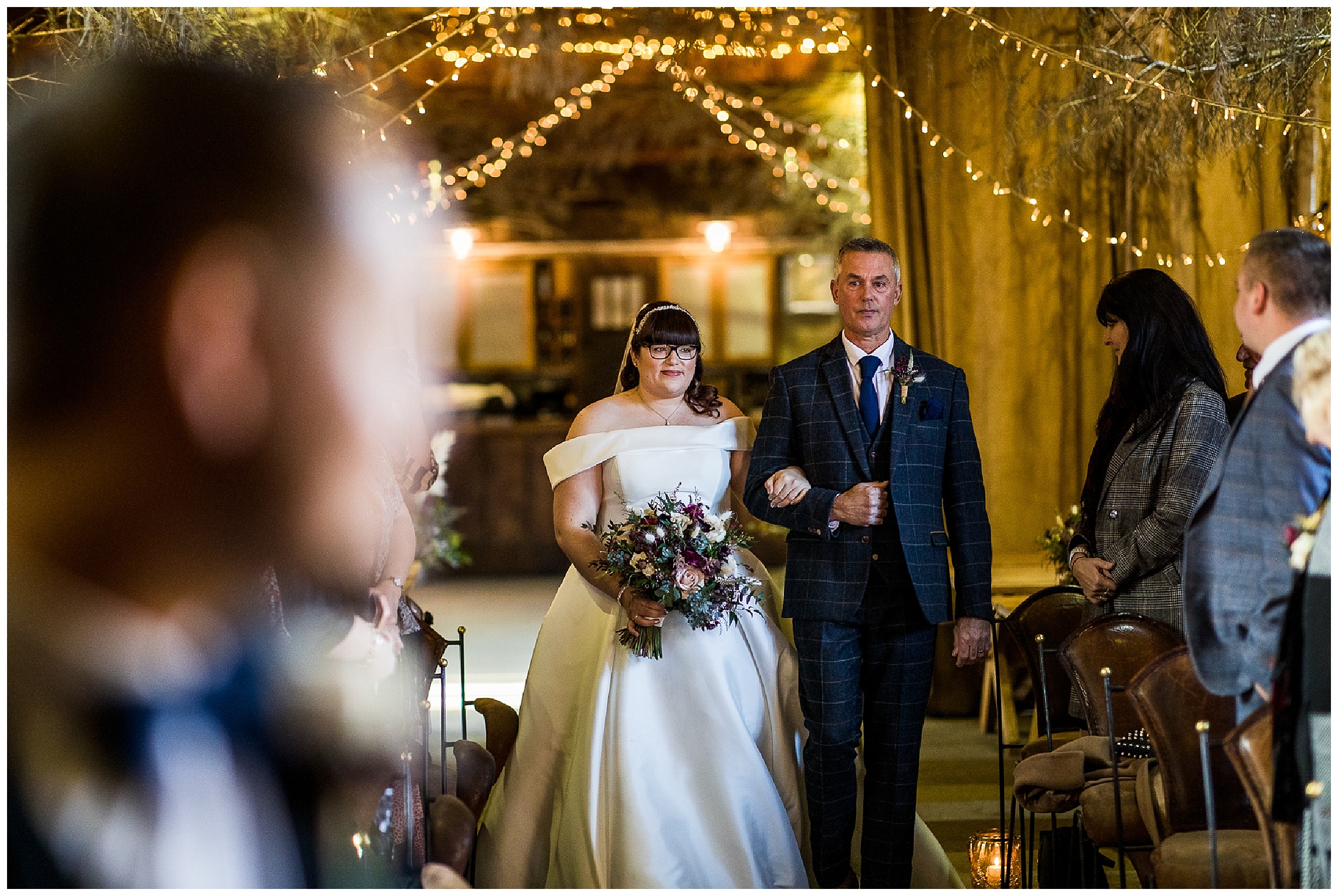 bride and her dad walking down aisle in wintery barn venue