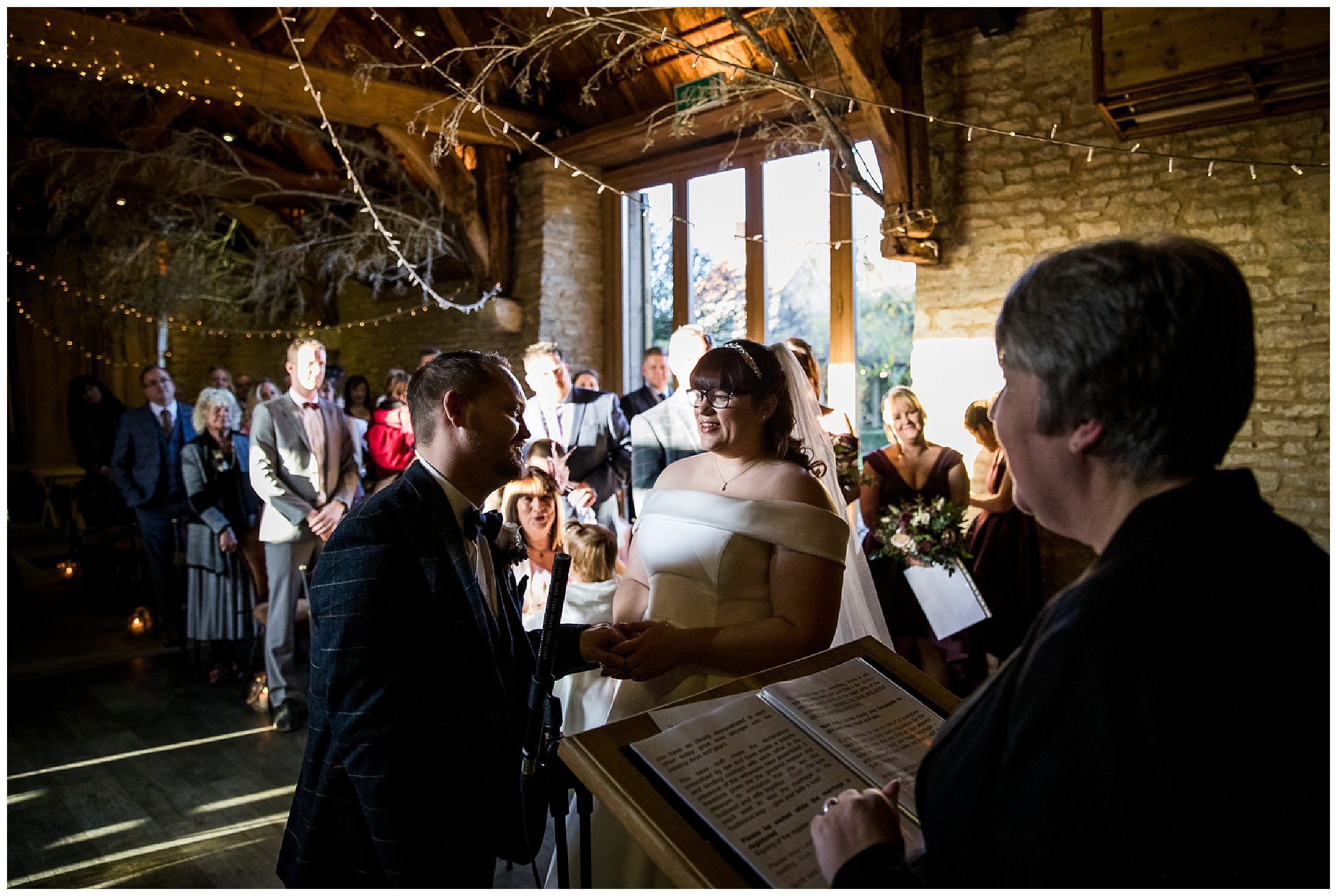 bride and groom exchange vows in tythe barn in launton