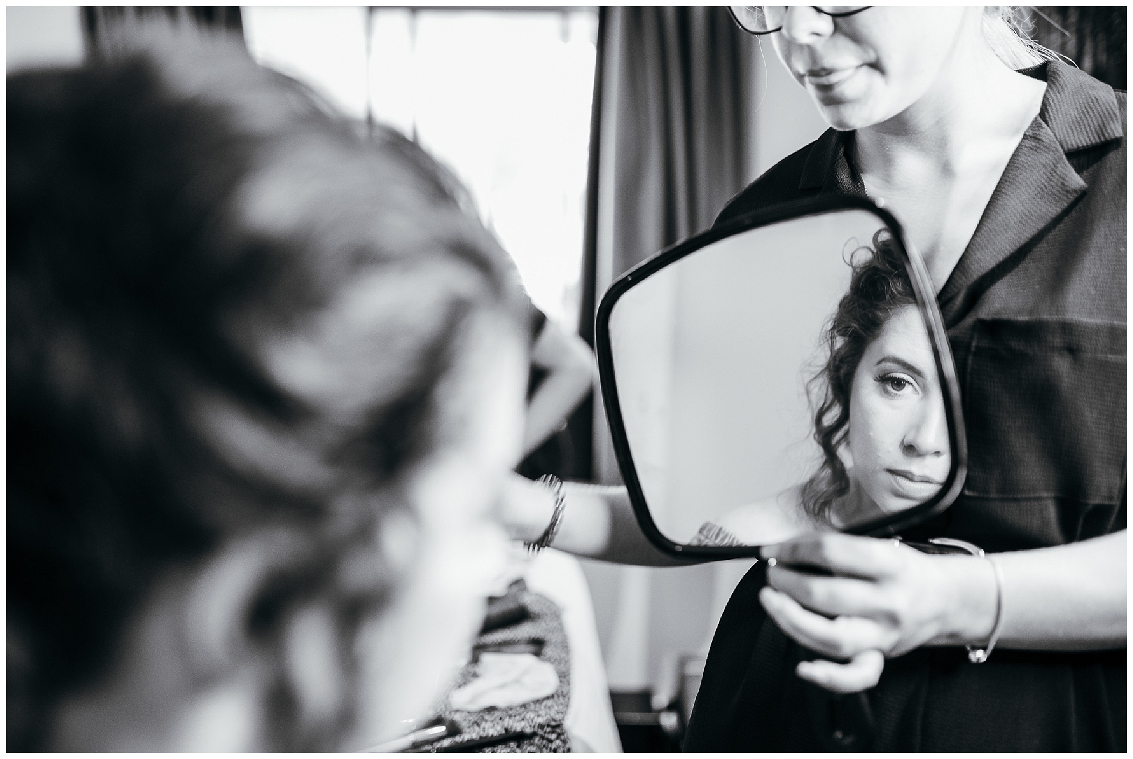 bride looking into mirror checking her eye make up