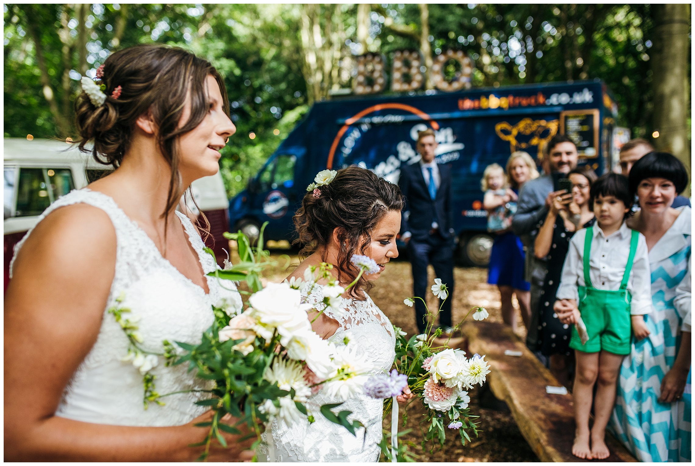 brides walk into wedding ceremony together at lilas wood