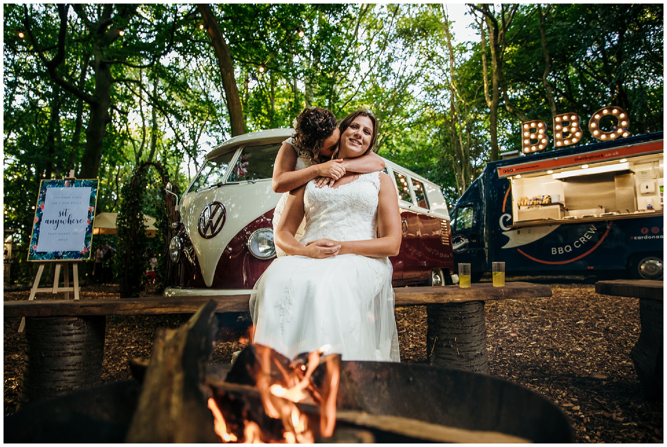 brides kiss in front of fire at night