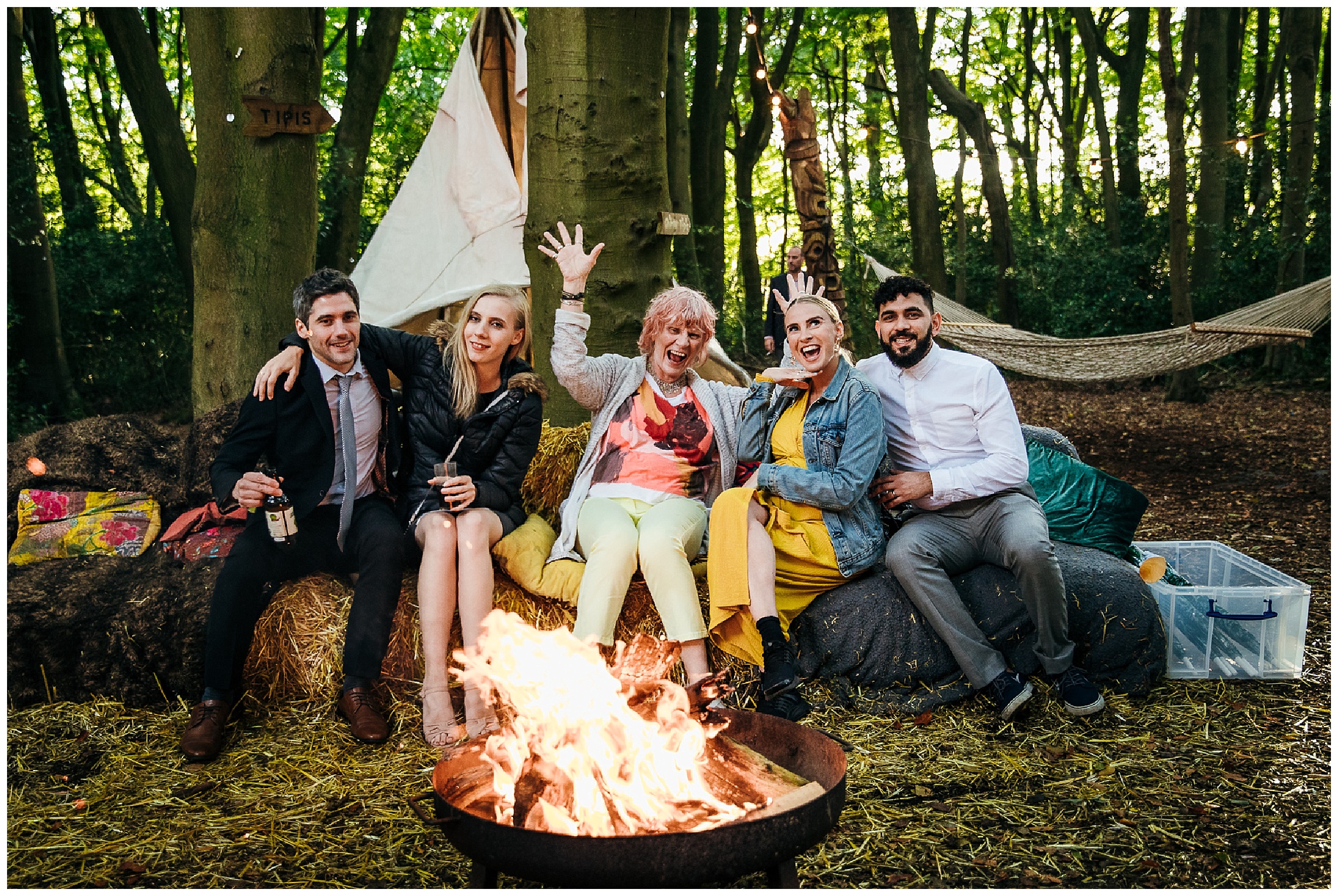 guests get warm in front of fire sat on hay bales