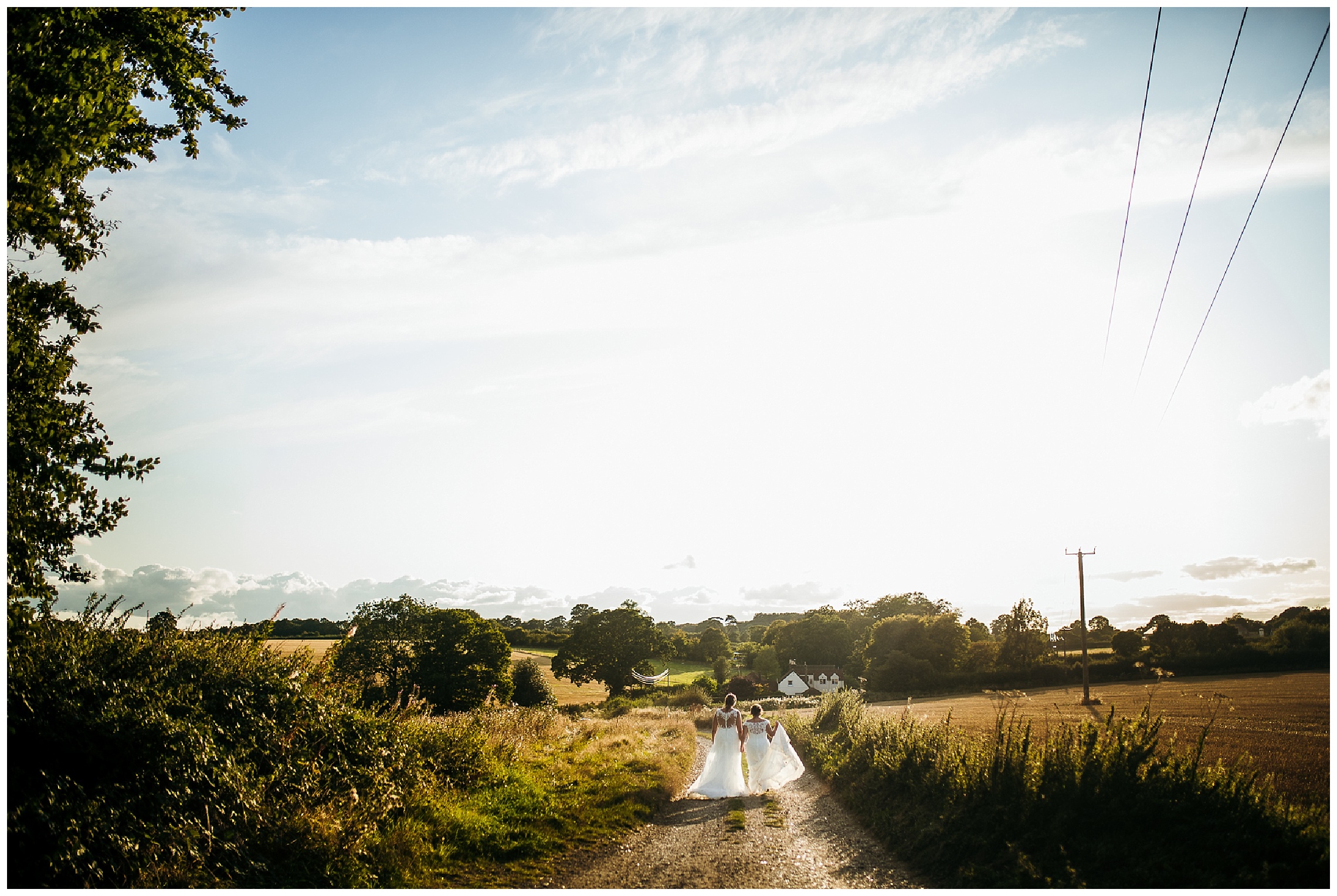 brides walk hand in hand towards sunset on wide driveway at lilas wood