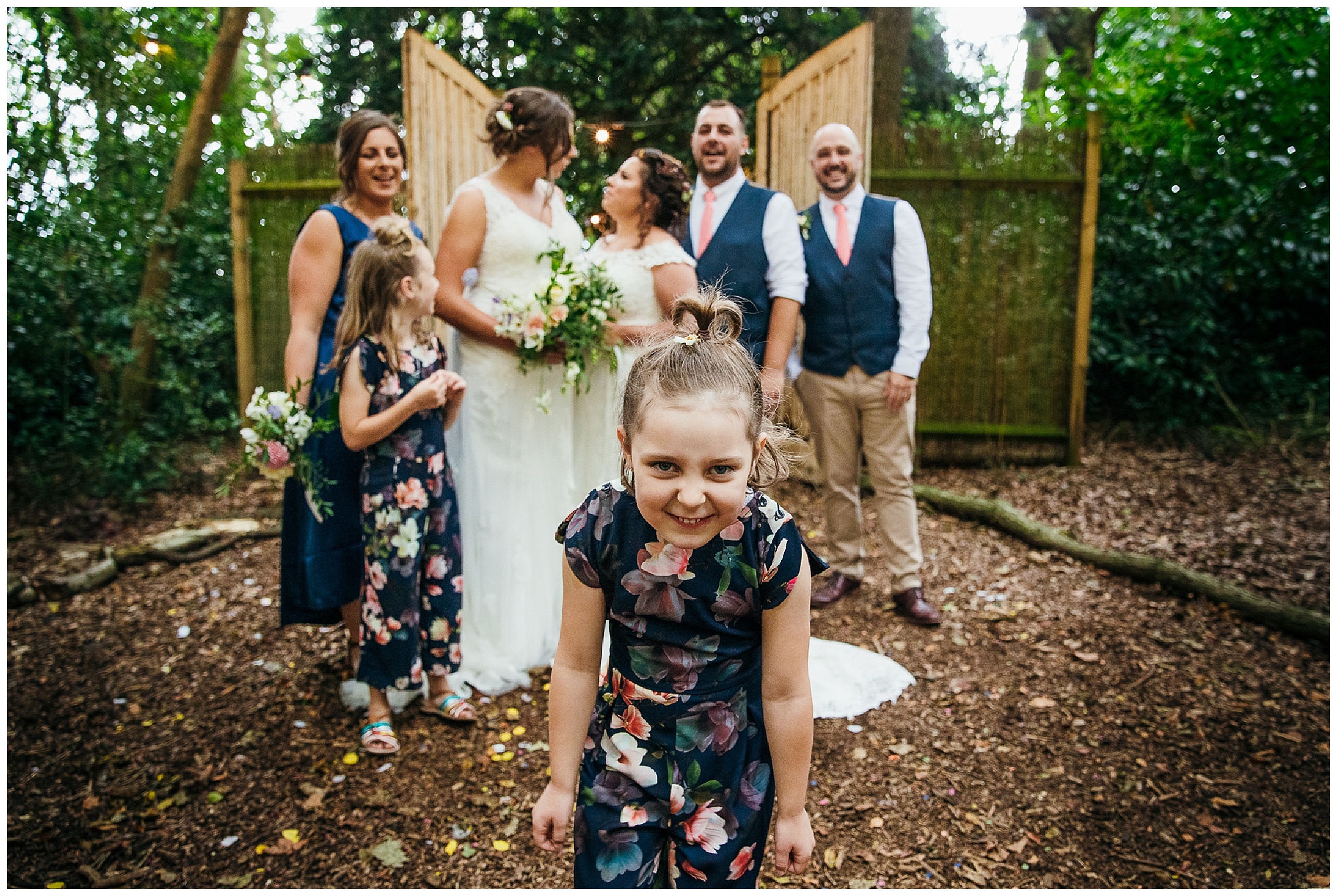 flower girl up close to camera with rest of bridal party in background