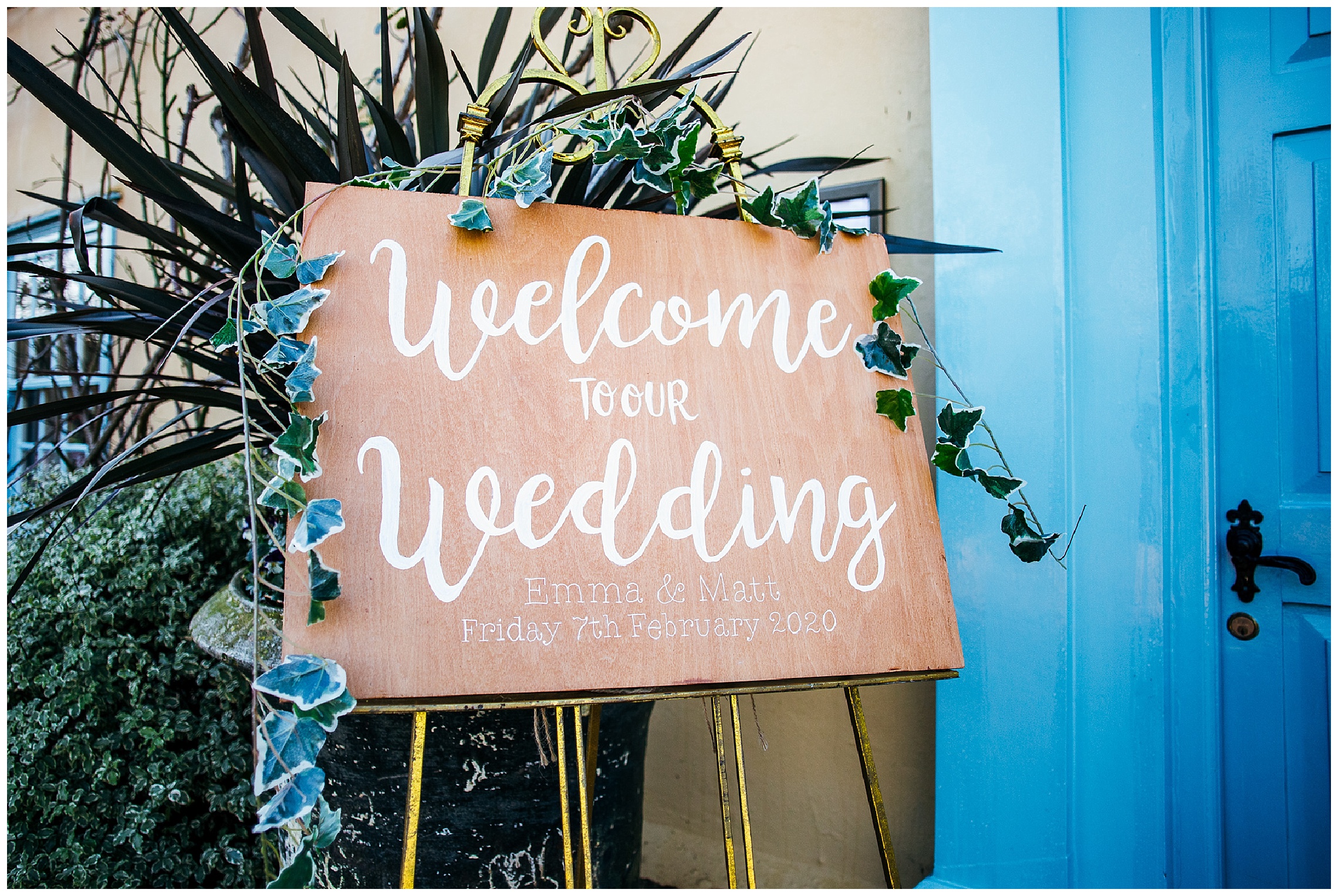 wooden wedding sign with faux ivy and white calligraphy writing