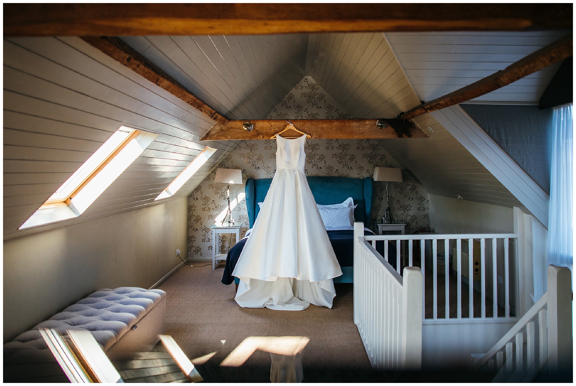 white wedding dress hanging from beams of bridal suite