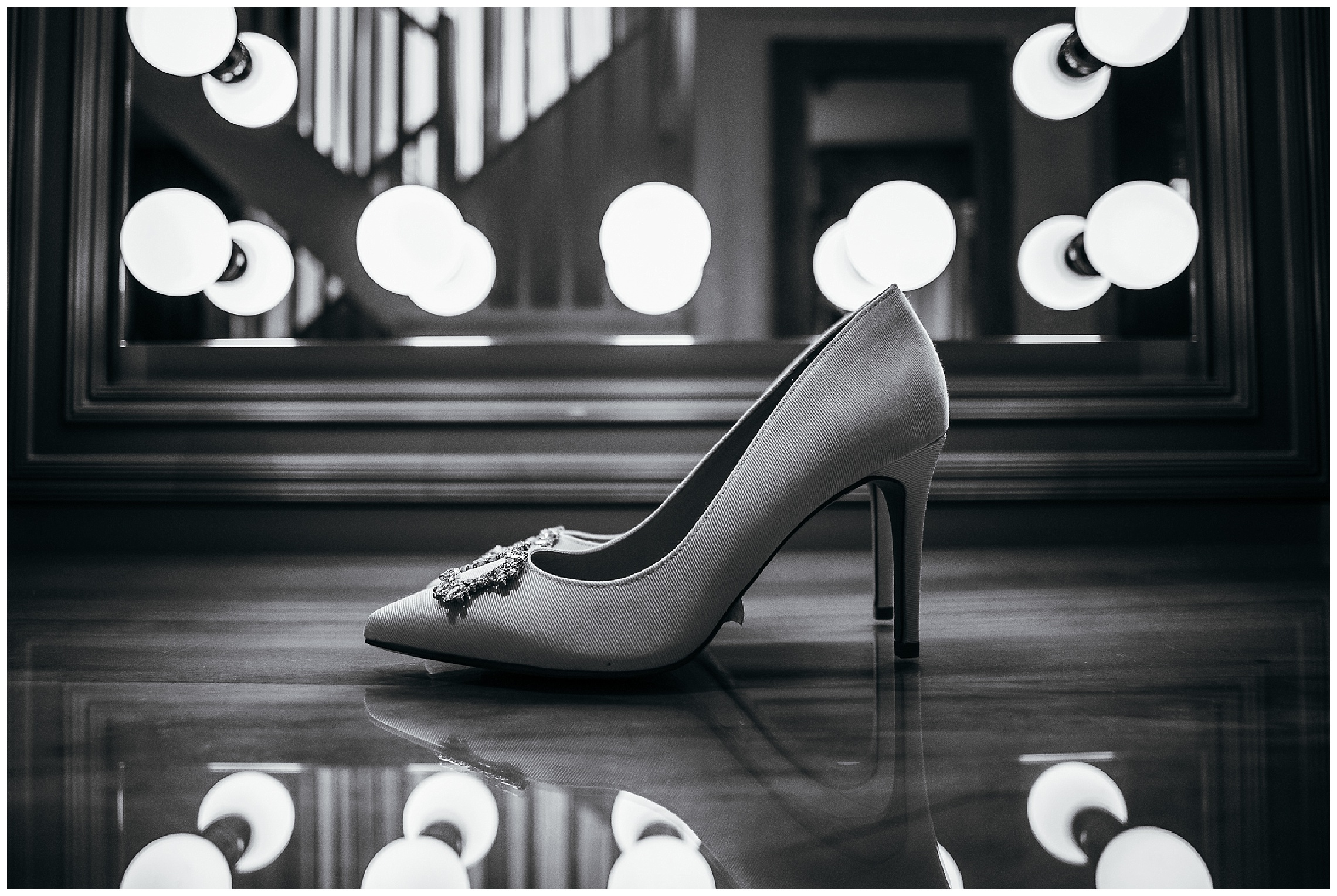 black and white image of white wedding shoes reflected in mirror