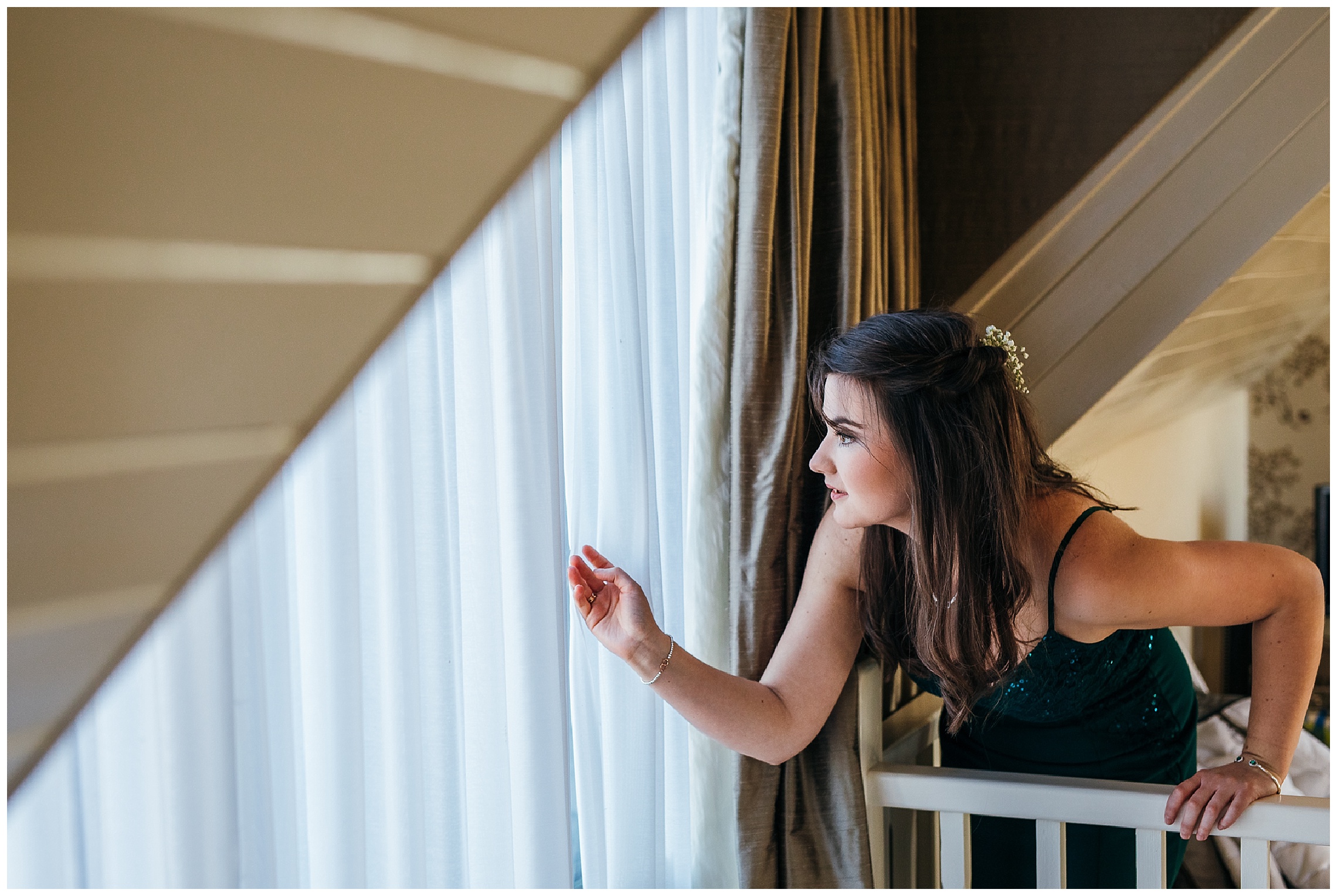 bridesmaid peels back curtain to peek outside