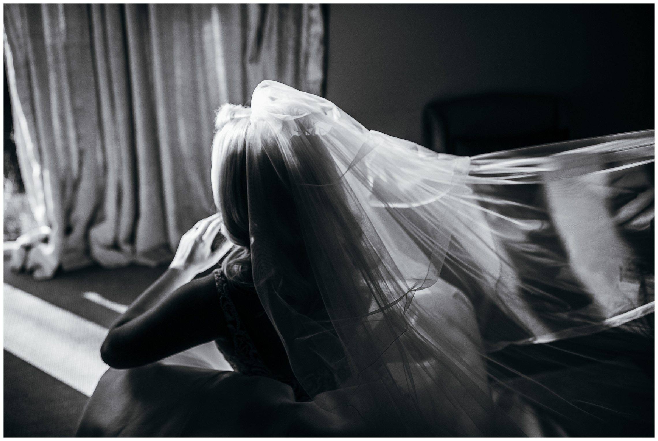 black and white dramatic image of bride sitting down in light