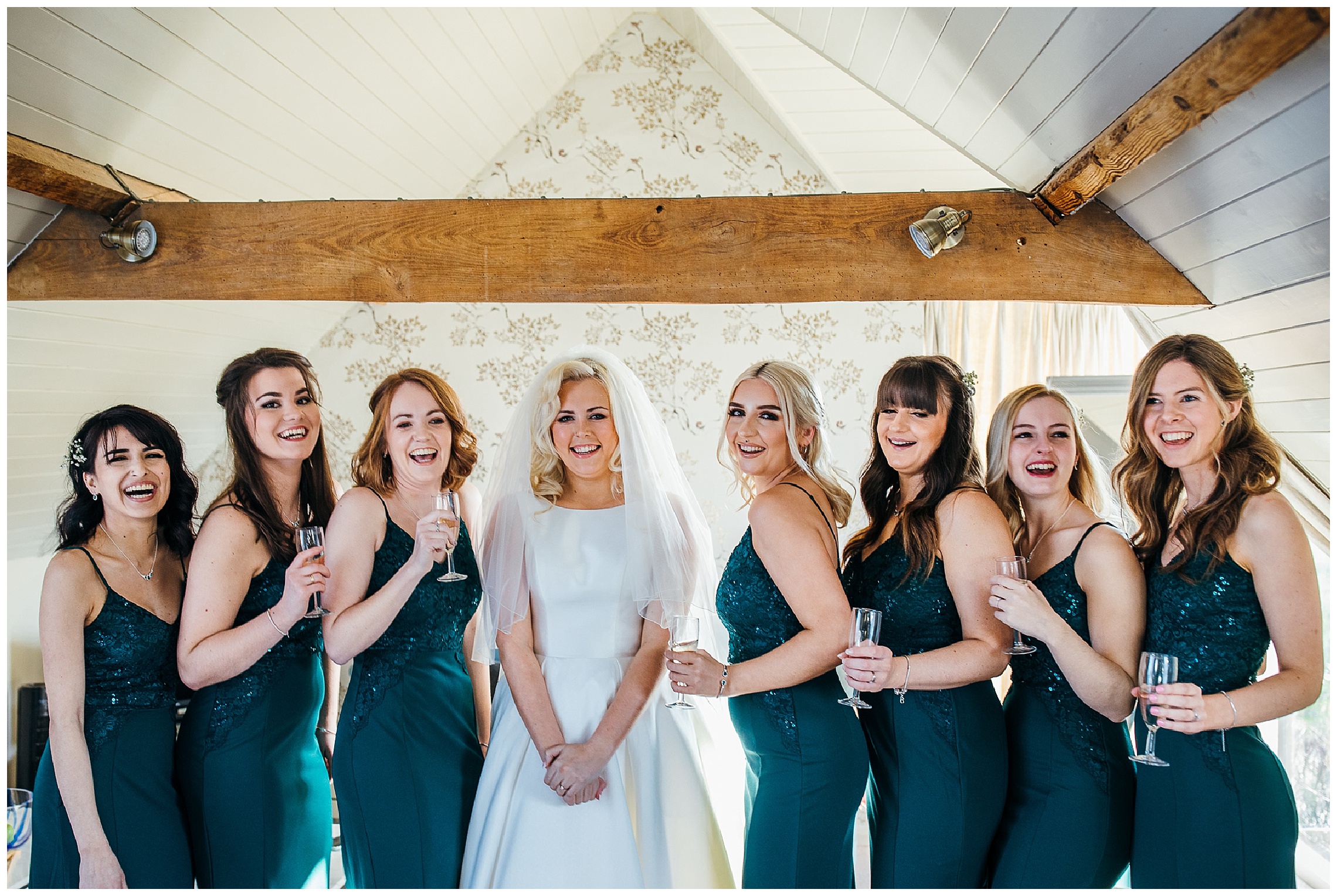 bride in white dress with 7 bridesmaids in green dresses