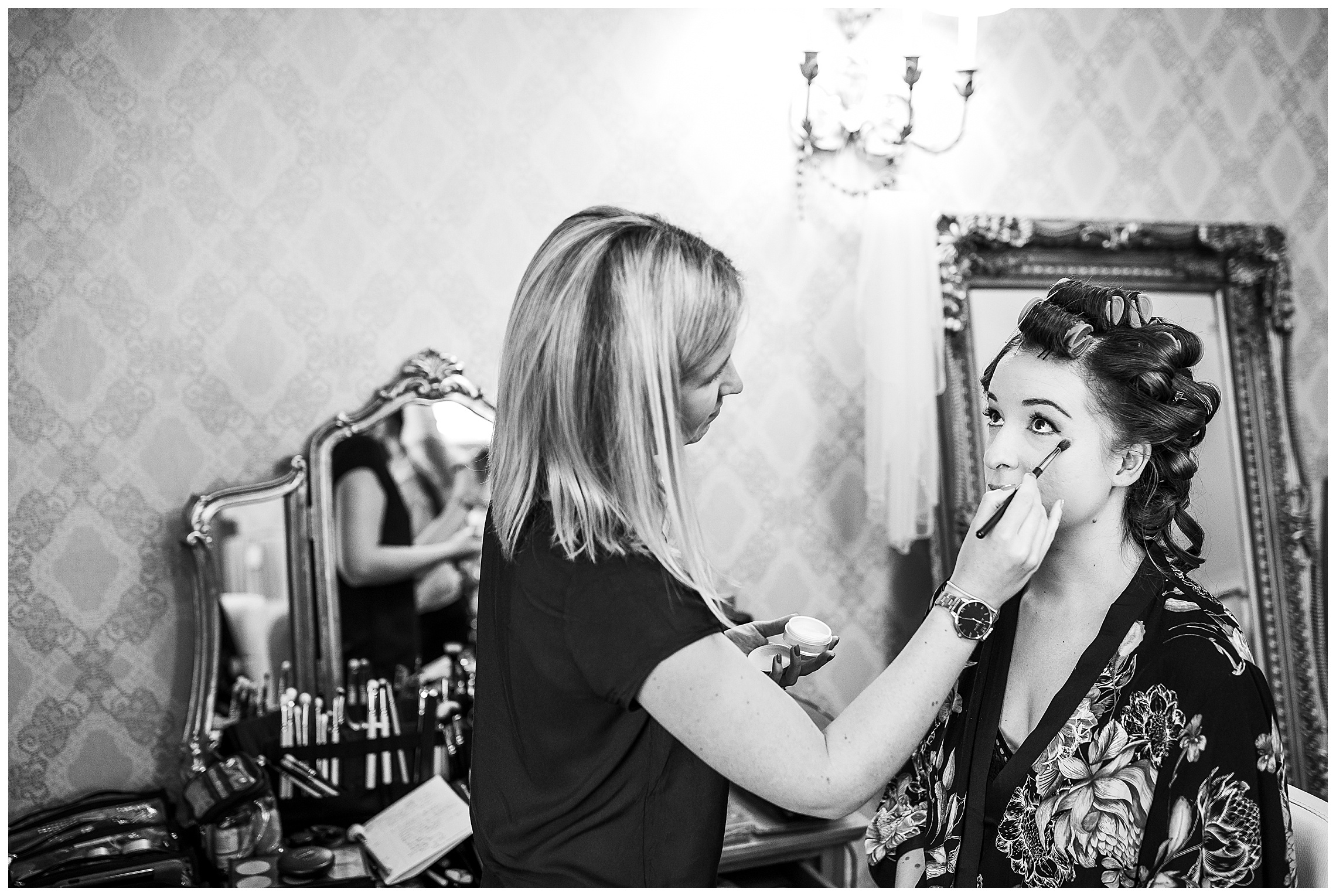 black and white image of bride having eye make up done in bassmead manor barns bridal suite