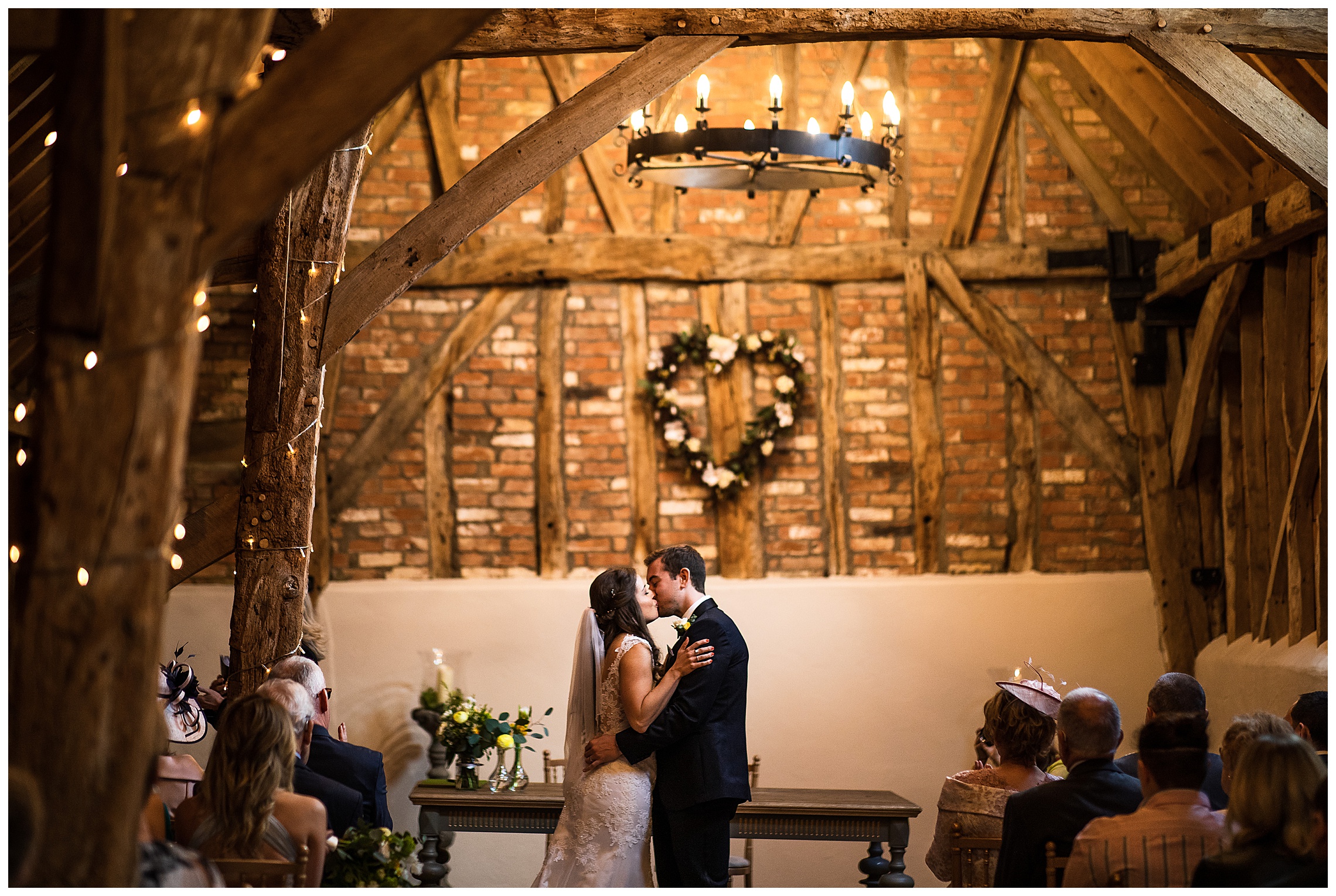 bride and groom first kiss in rickety barn at bassmead