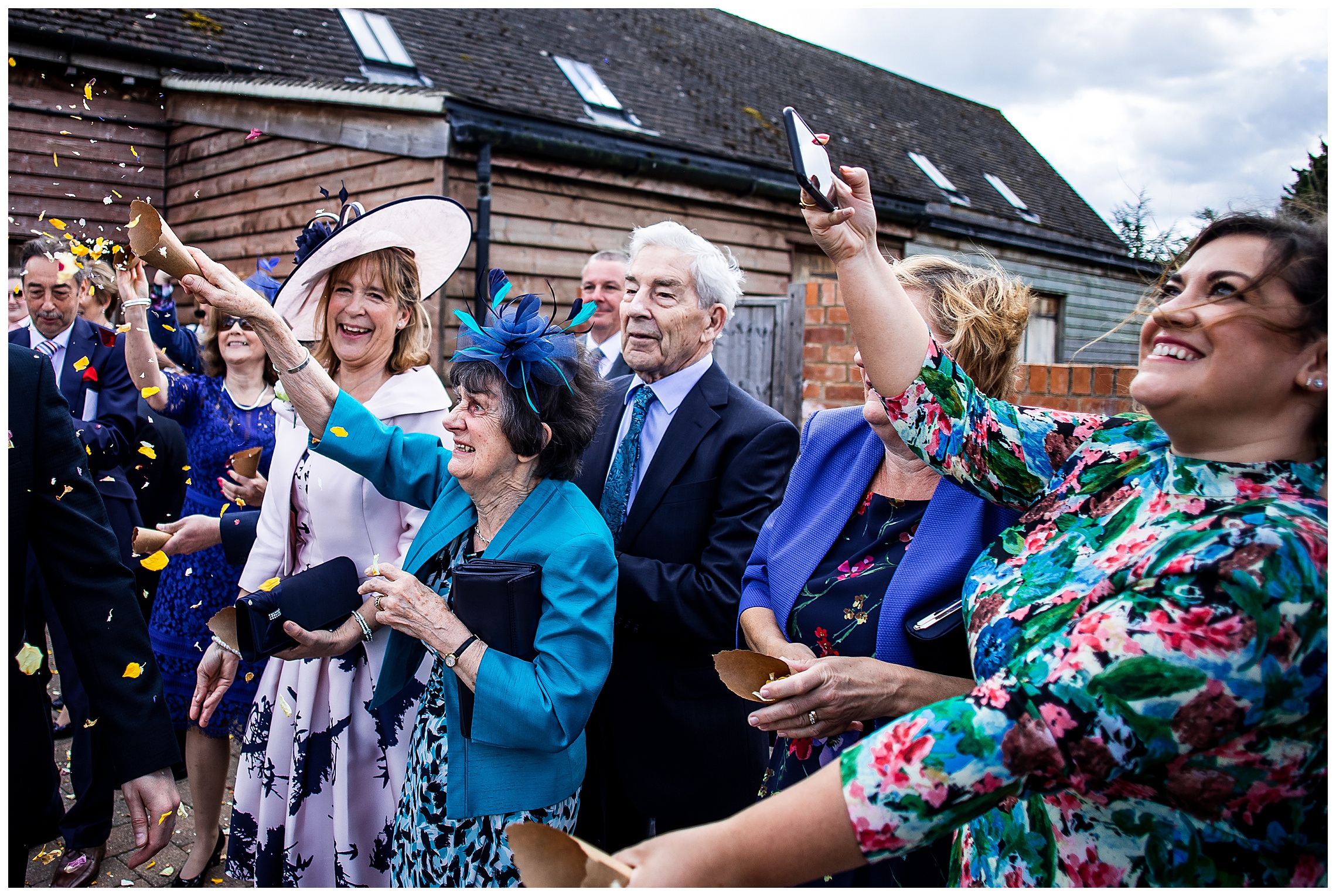 wedding guests smiling and throwing confetti