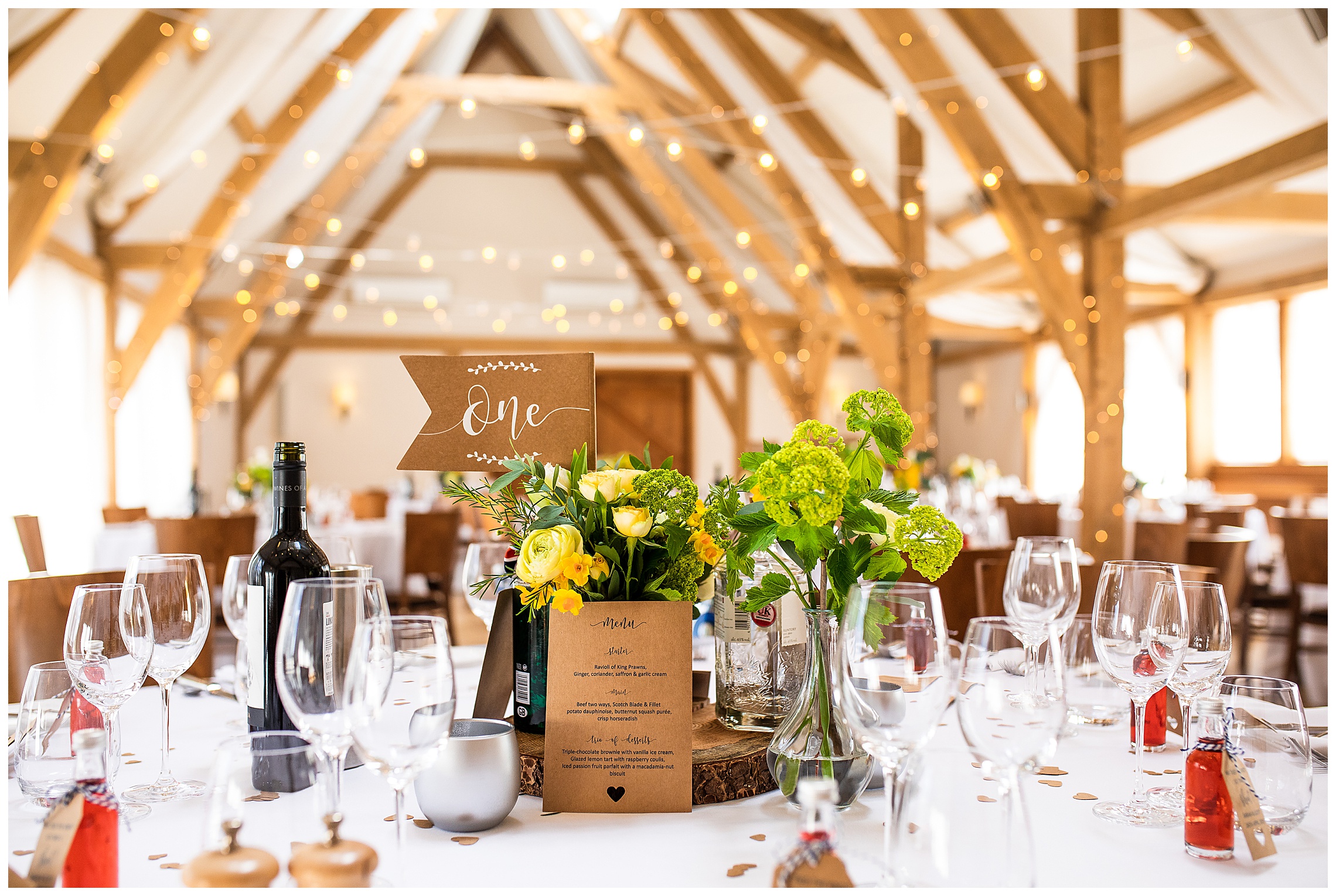 yellow flowers and festoon lights in barn venue