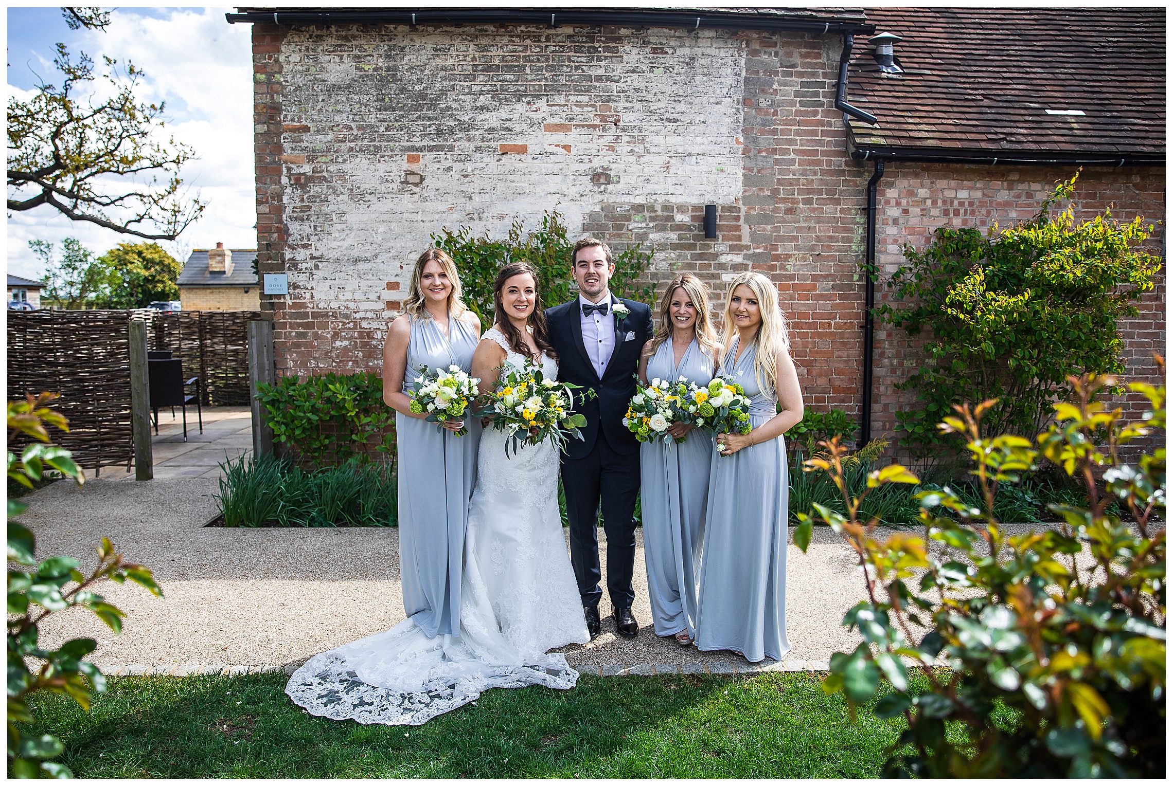 bridesmaids in blue dresses with bride and groom at bassmead