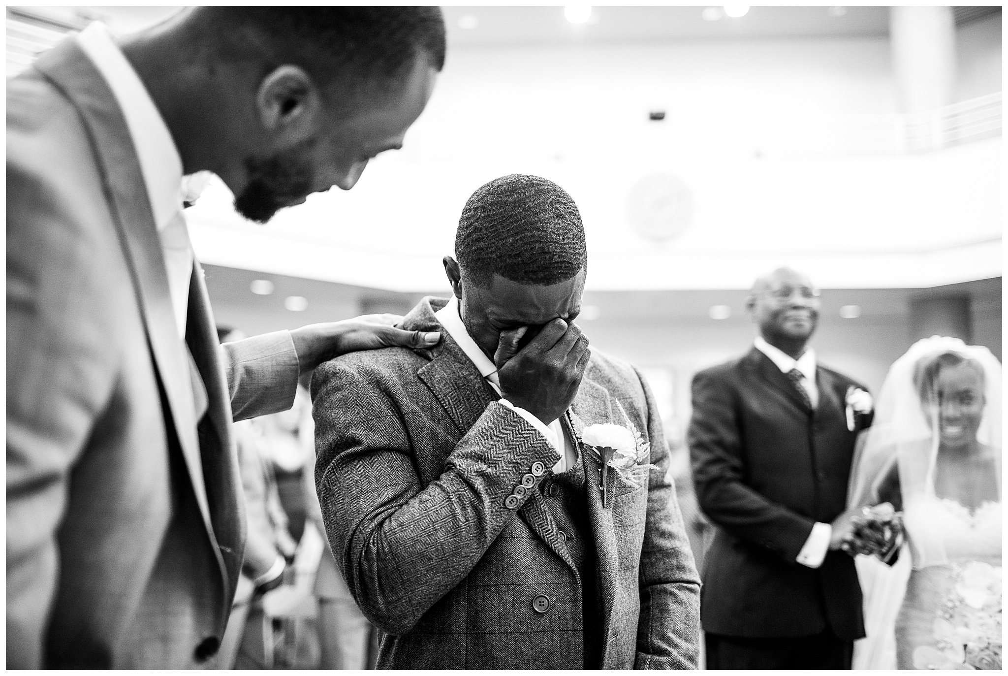 award winning image of bride and groom, groom has hand other eyes and crying