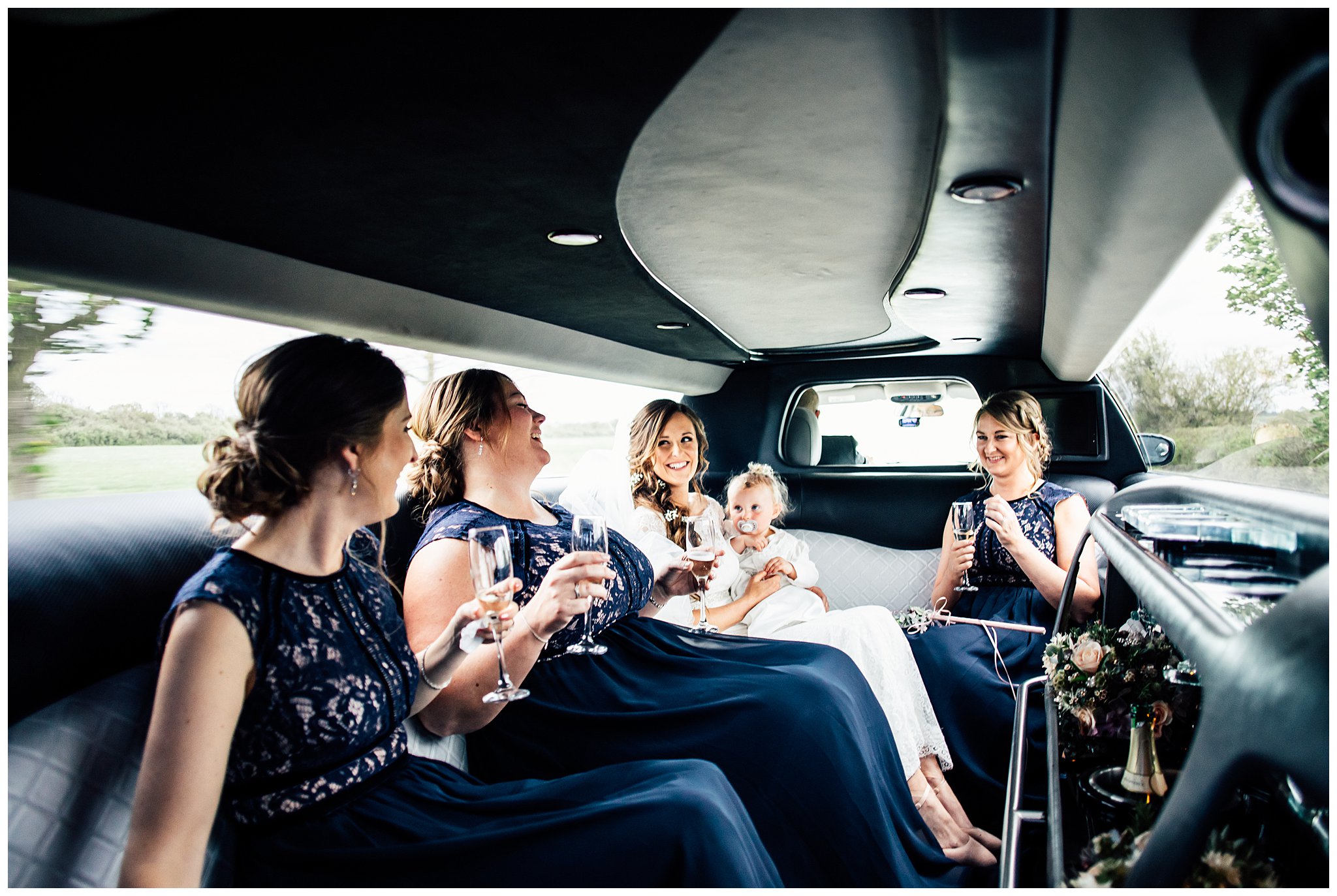 bride and bridesmaids laughing in limousine