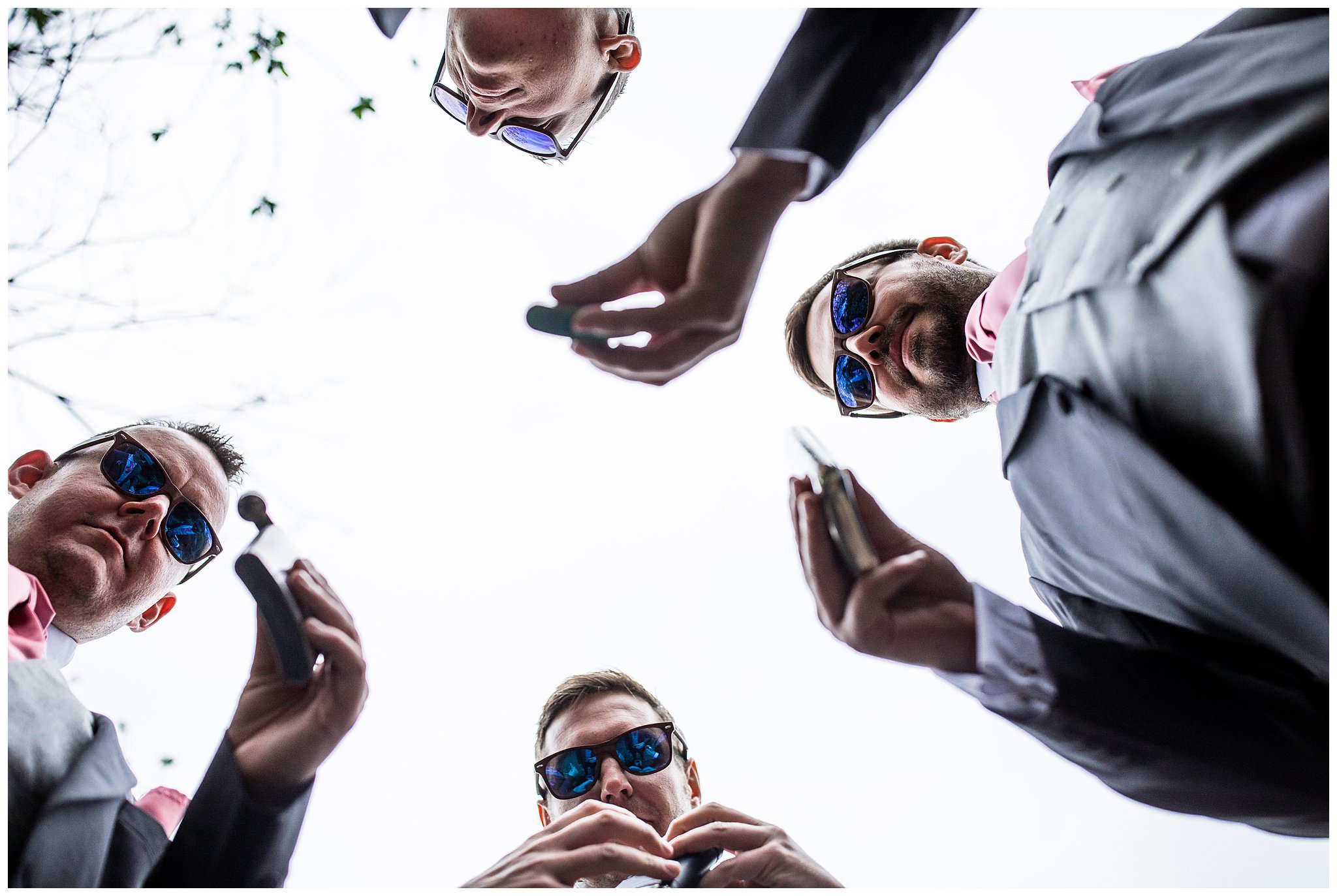 image of groomsmen from floor perspective drinking from hip flasks