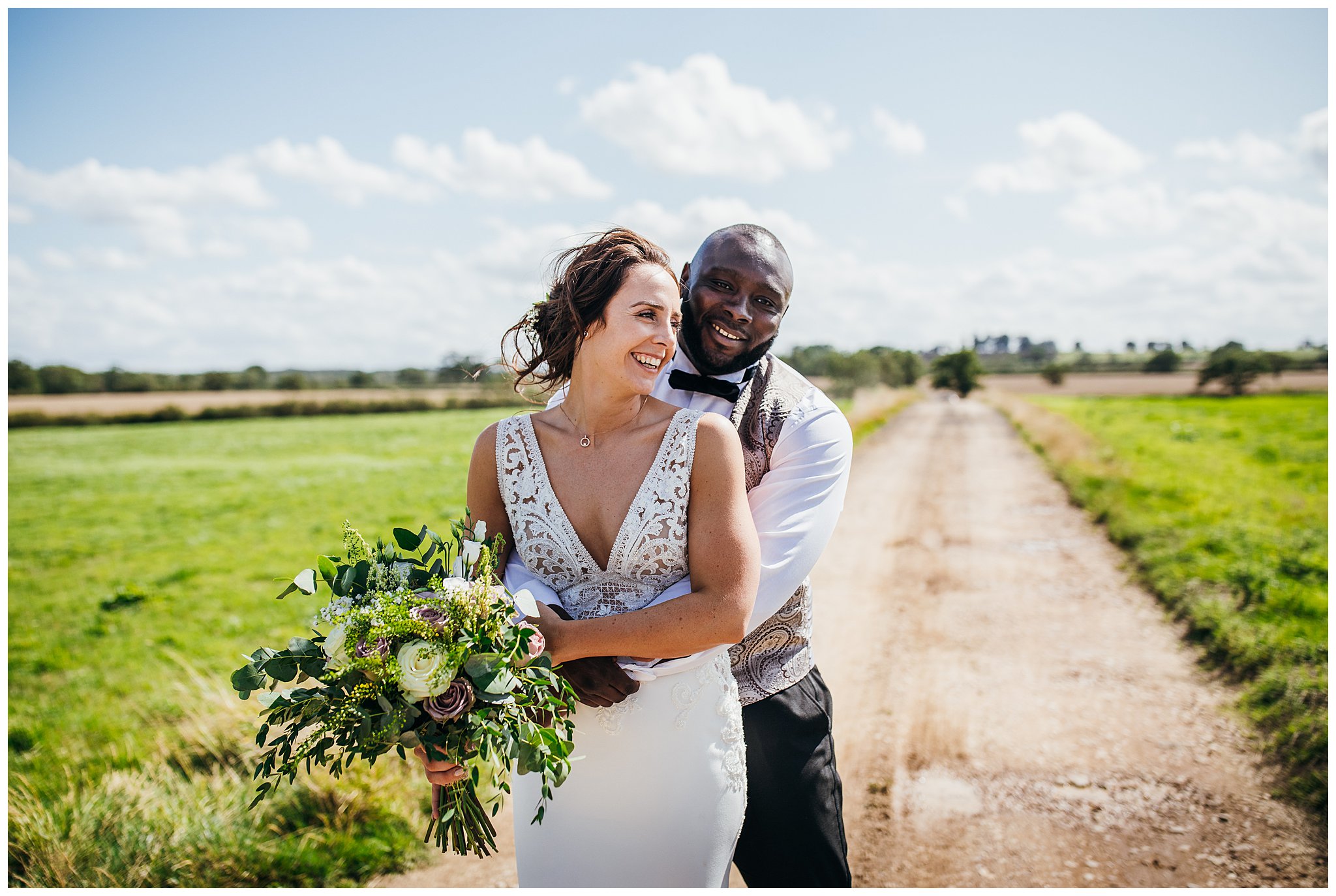 bride and groom on long driveway with wind blowing hair at winters tale