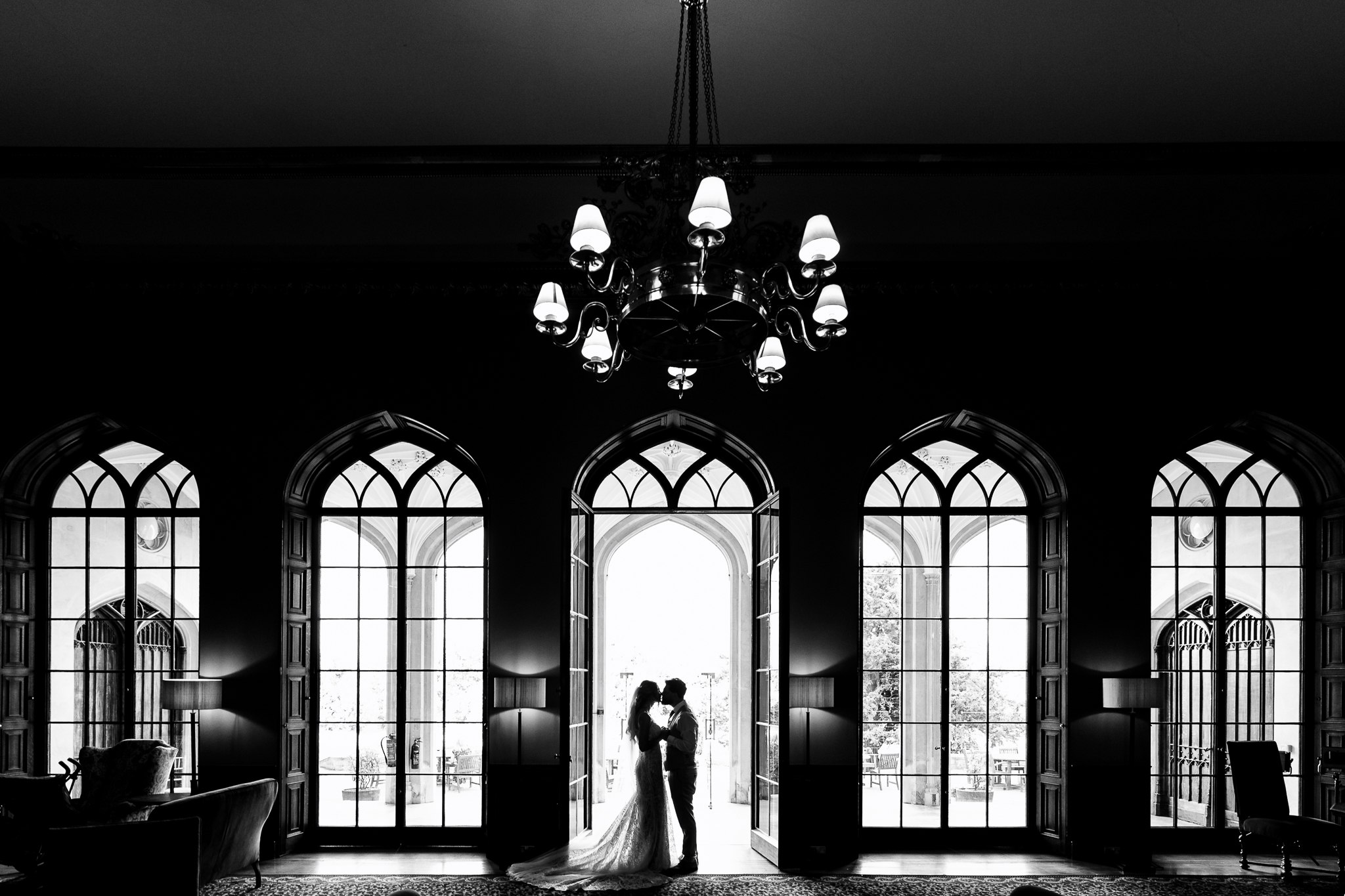 bride and groom stood in front of symmetrical windows at ashridge house 