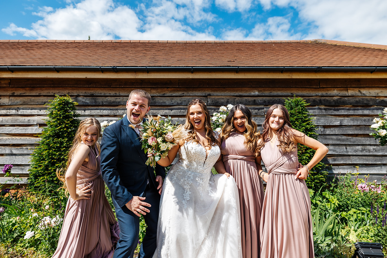 Bride, bridesmaids and a groomsmen outside Bassmead, Bridesmaids are in pink dresses 