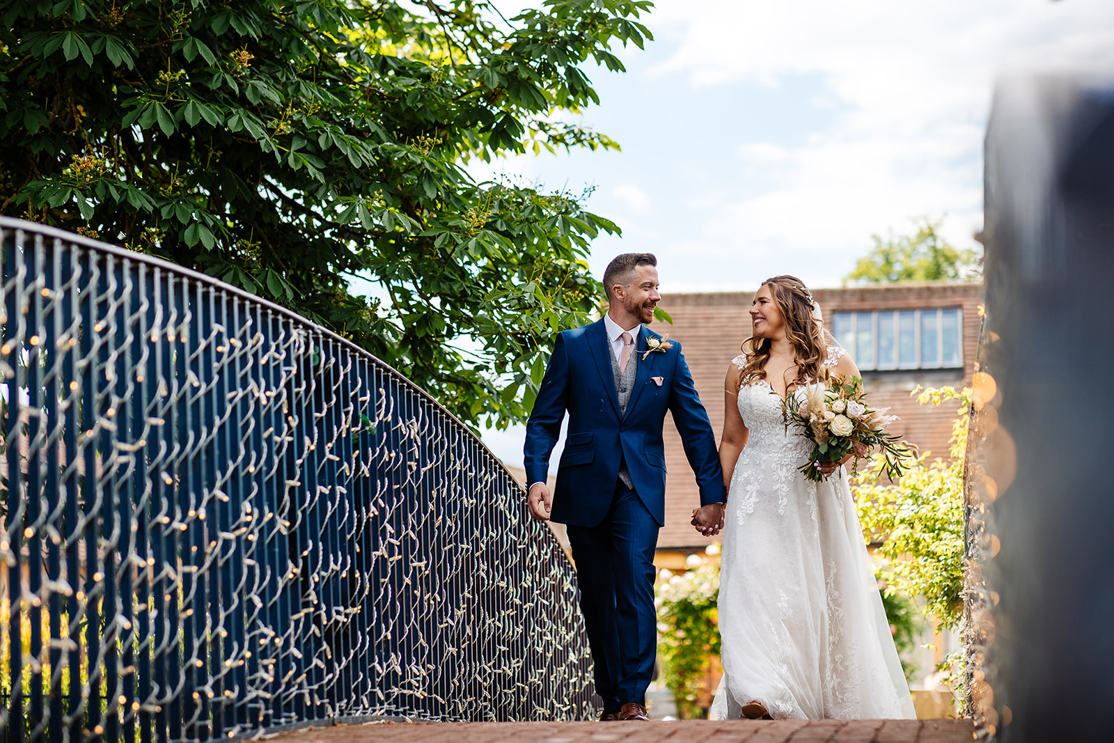 Couple take a walk across the bridge in Bassmeads grounds 