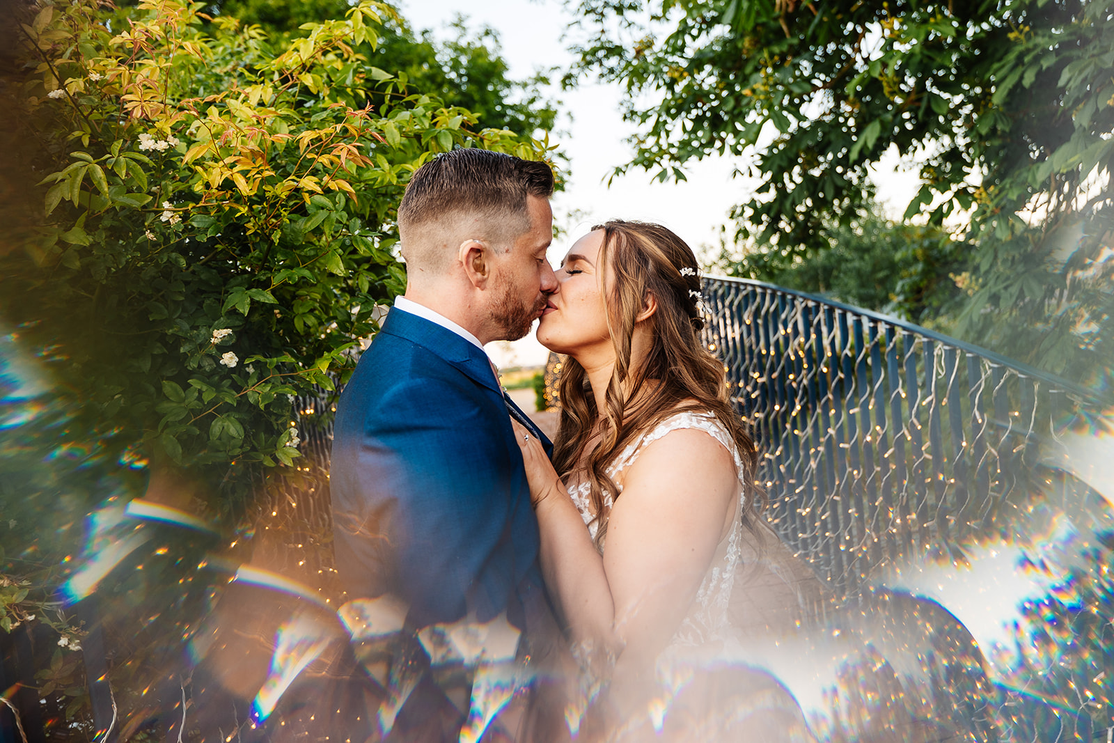 Couple share kiss on bridge in grounds of Bassmead