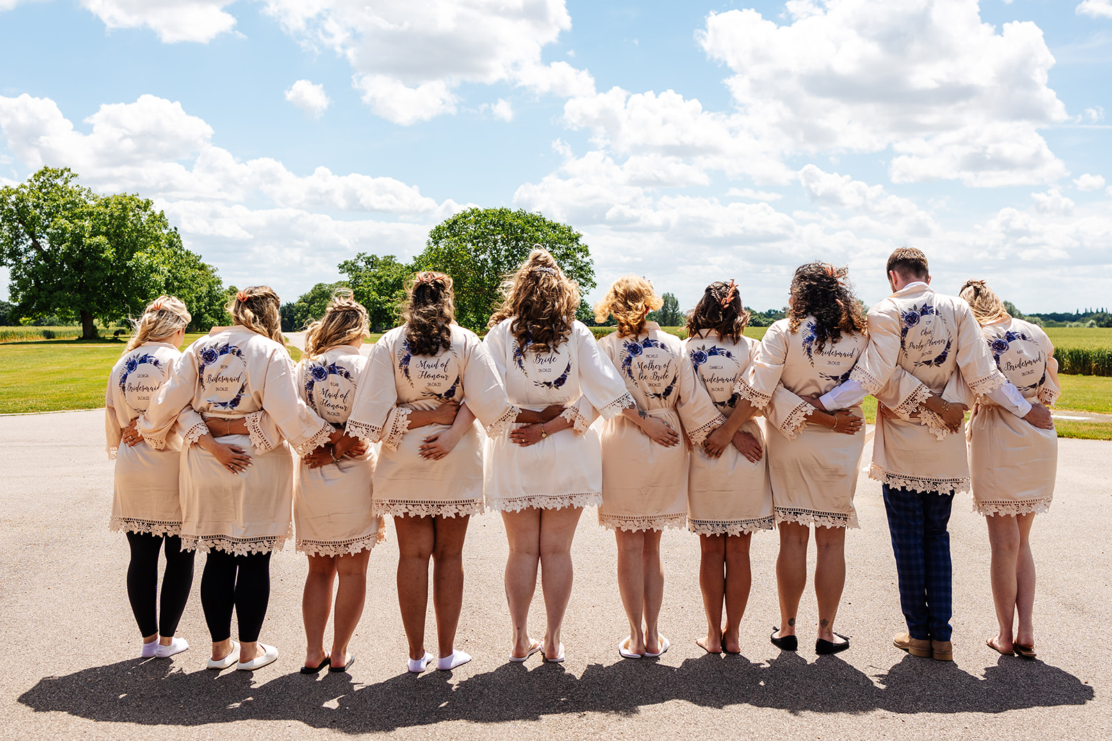 Bride tribe in personalised pink satin robes, with backs to the camera 