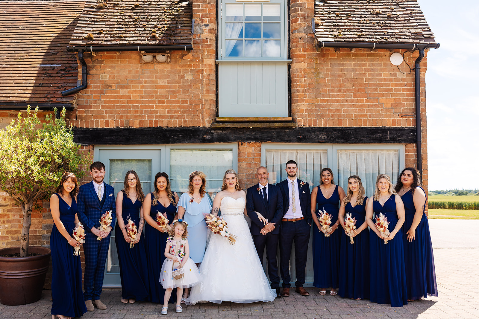 Bride takes centre with bridal party, outside before the ceremony 