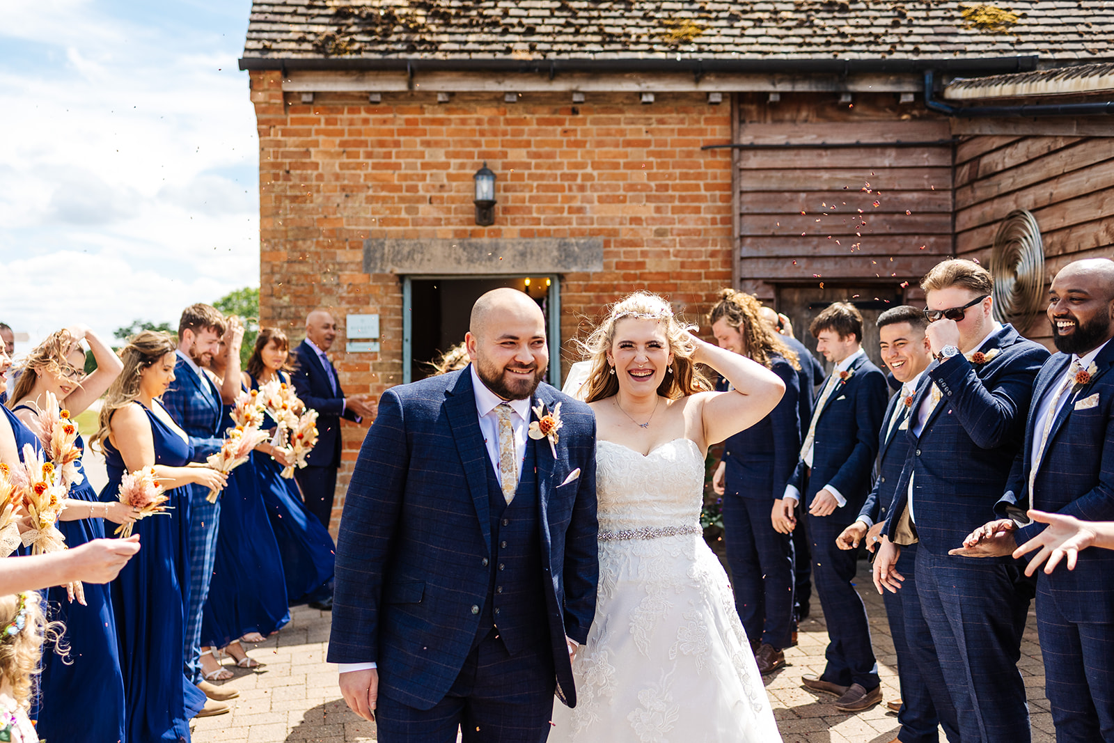 Couple exit ceremony with confetti thrown by guests 