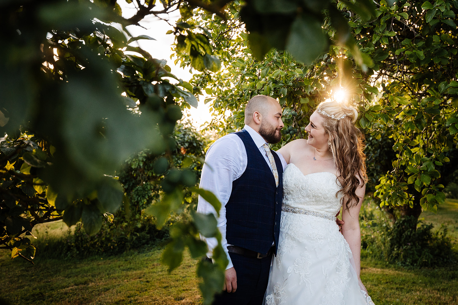 Couple take a walk at sunset through trees 