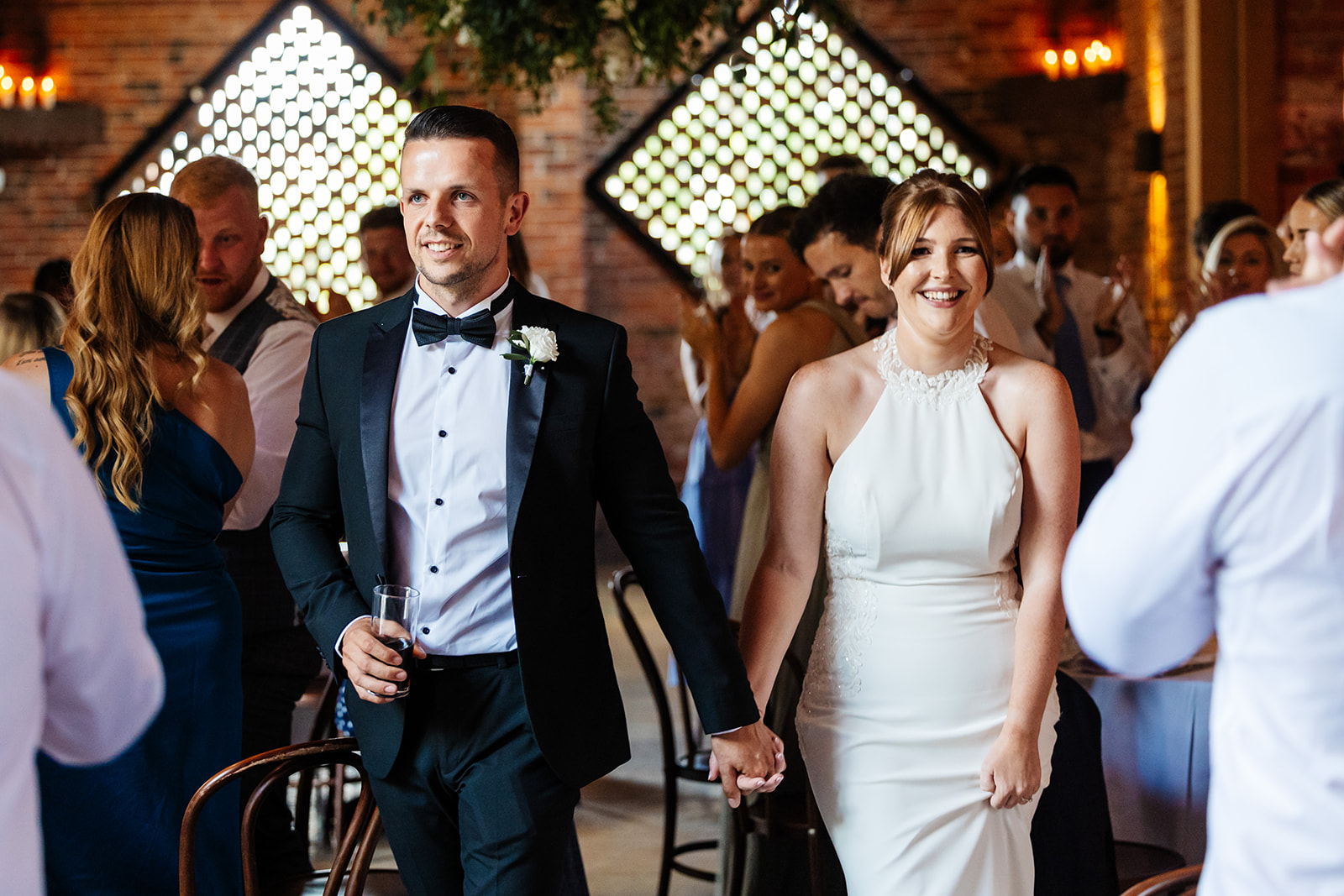 Couples entrance into wedding breakfast, guests are standing and clapping 