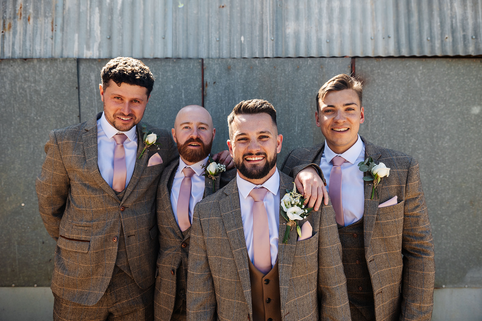 Groom with groomsmen with corrugated metal in the background 