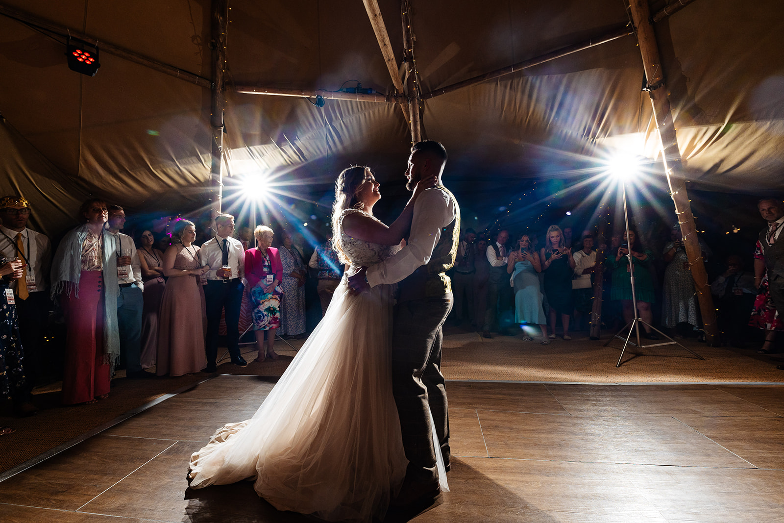 Couples first dance in tipi with fairy lights in the background 