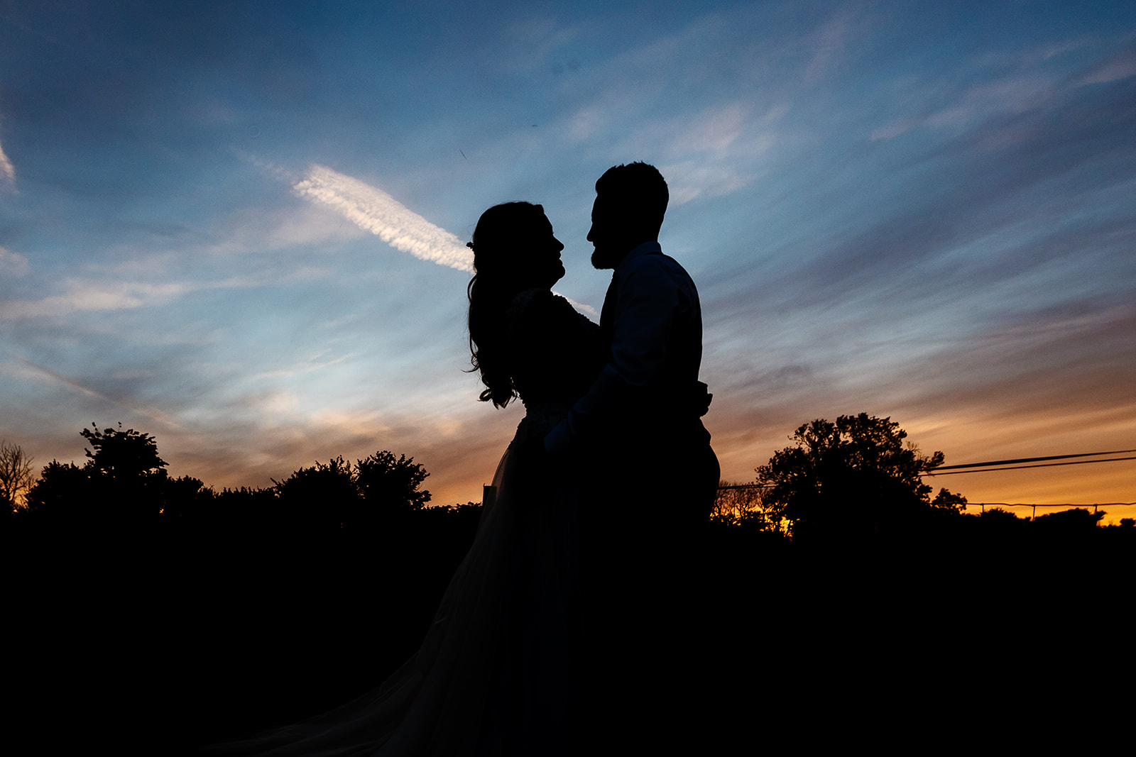 Couple embrace with sunset in the background 