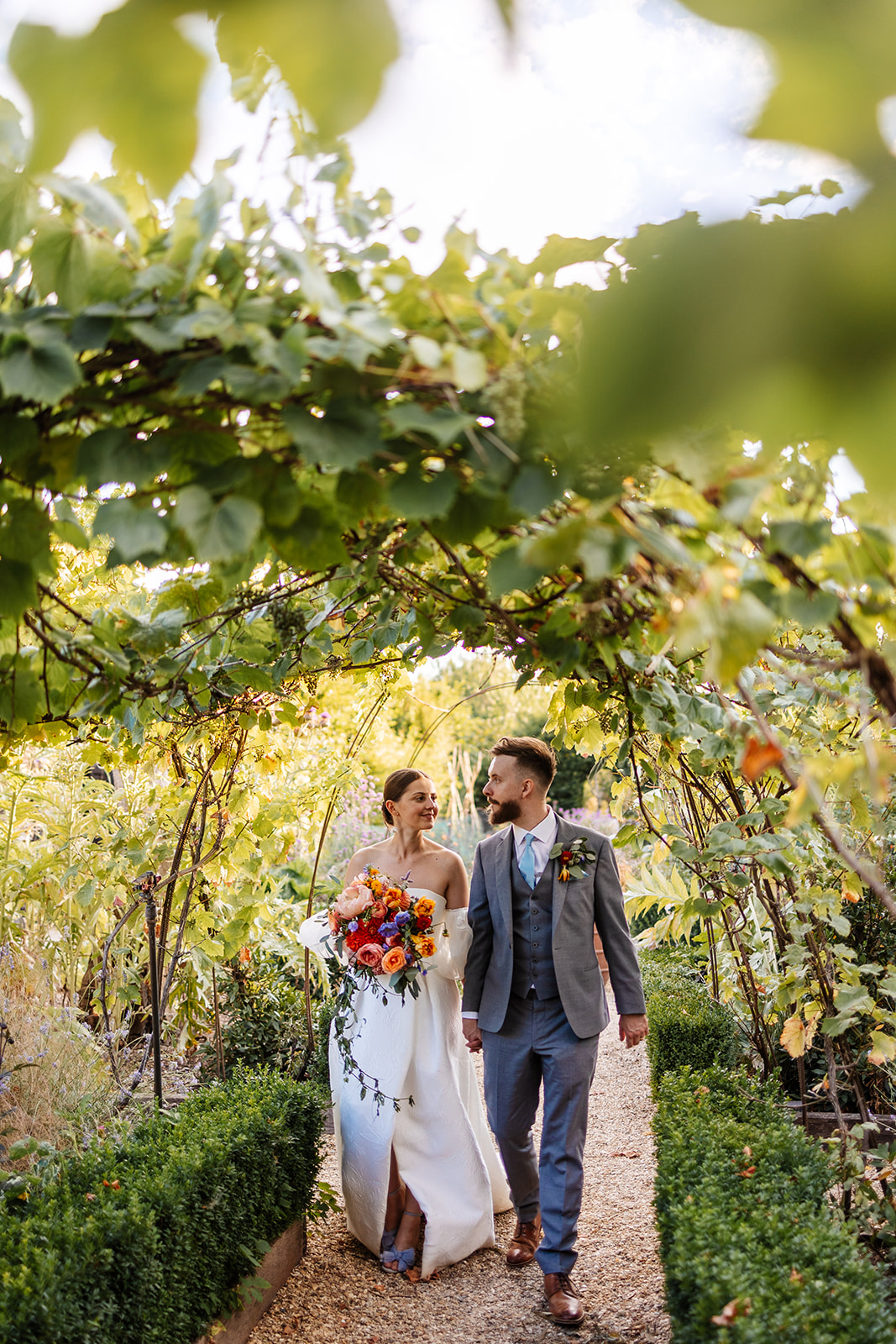 Couple walking under garden archway 