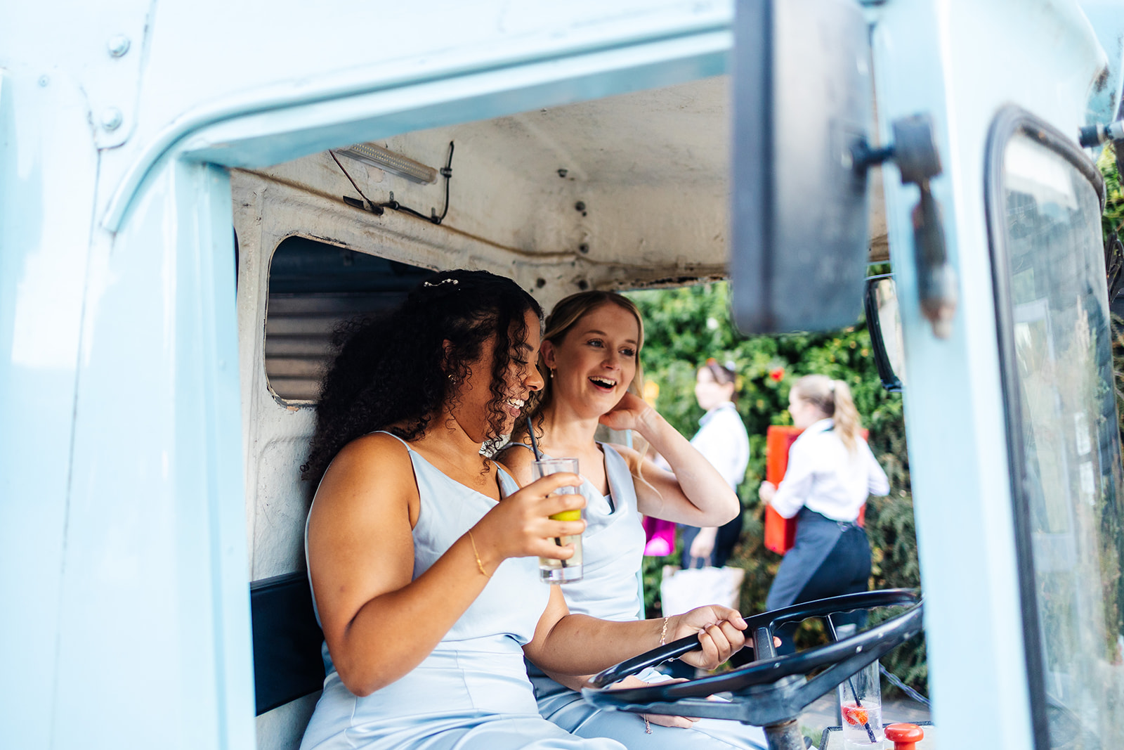 Bridesmaids laughing in vintage truck