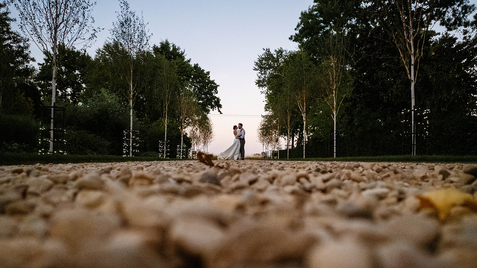 Couple in tree-lined driveway 