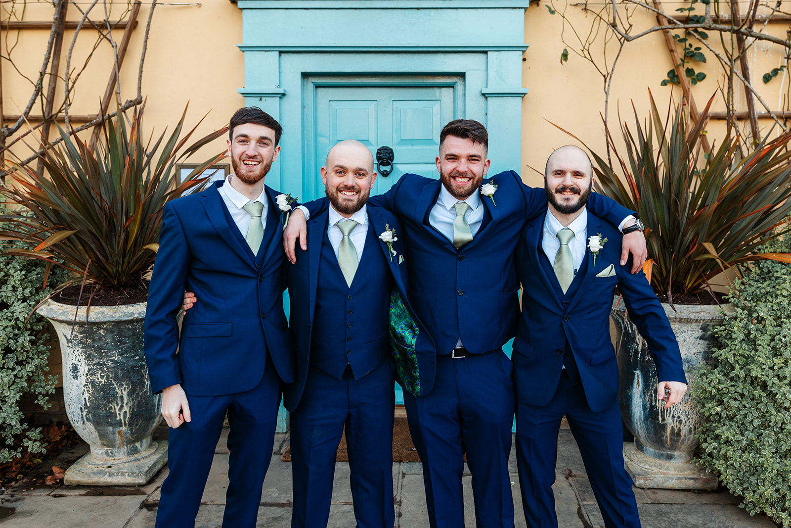 Groom and Groomsmen outside main house with blue suits and green ties 