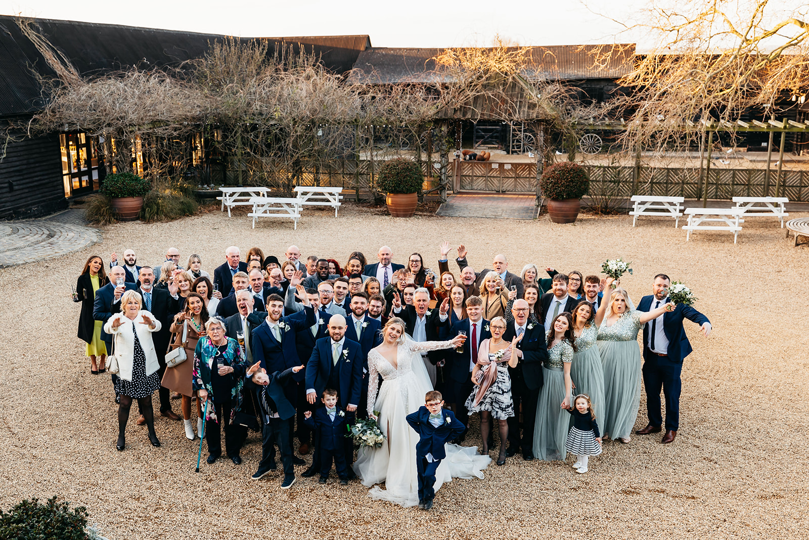 Group photo with all guests waving in courtyard 